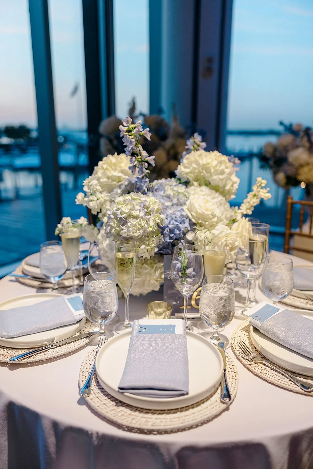 Custom, personalized dinner menu with coastal blue deckled-edge name tag with white in and gold clip and hydrangea background for a classic, elegant coastal wedding at the ICA in Boston, MA