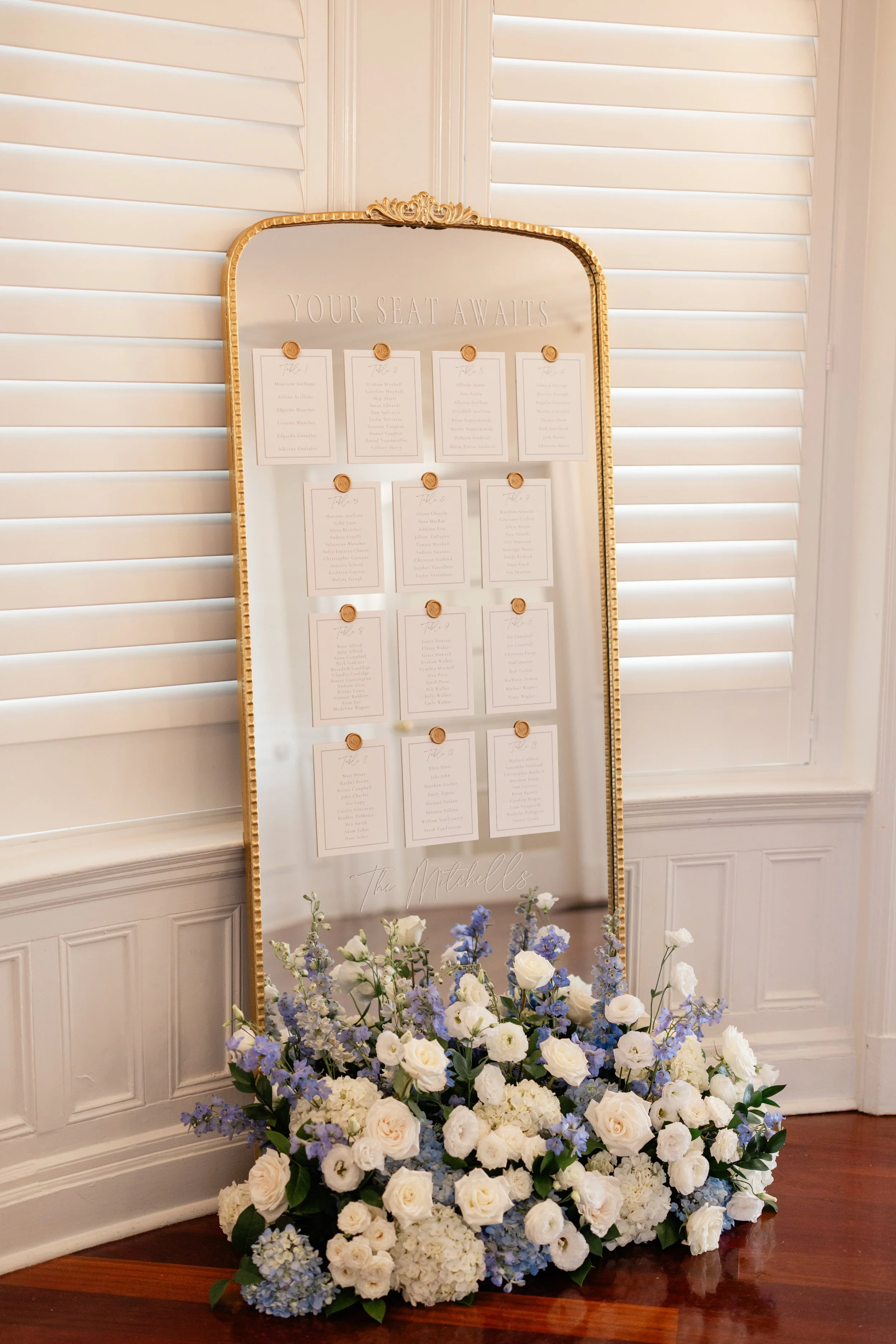 Ornate gold mirror wedding seating chart featuring luxury card stock and custom wax seals at a Newport wedding reception - OceanCliff Hotel