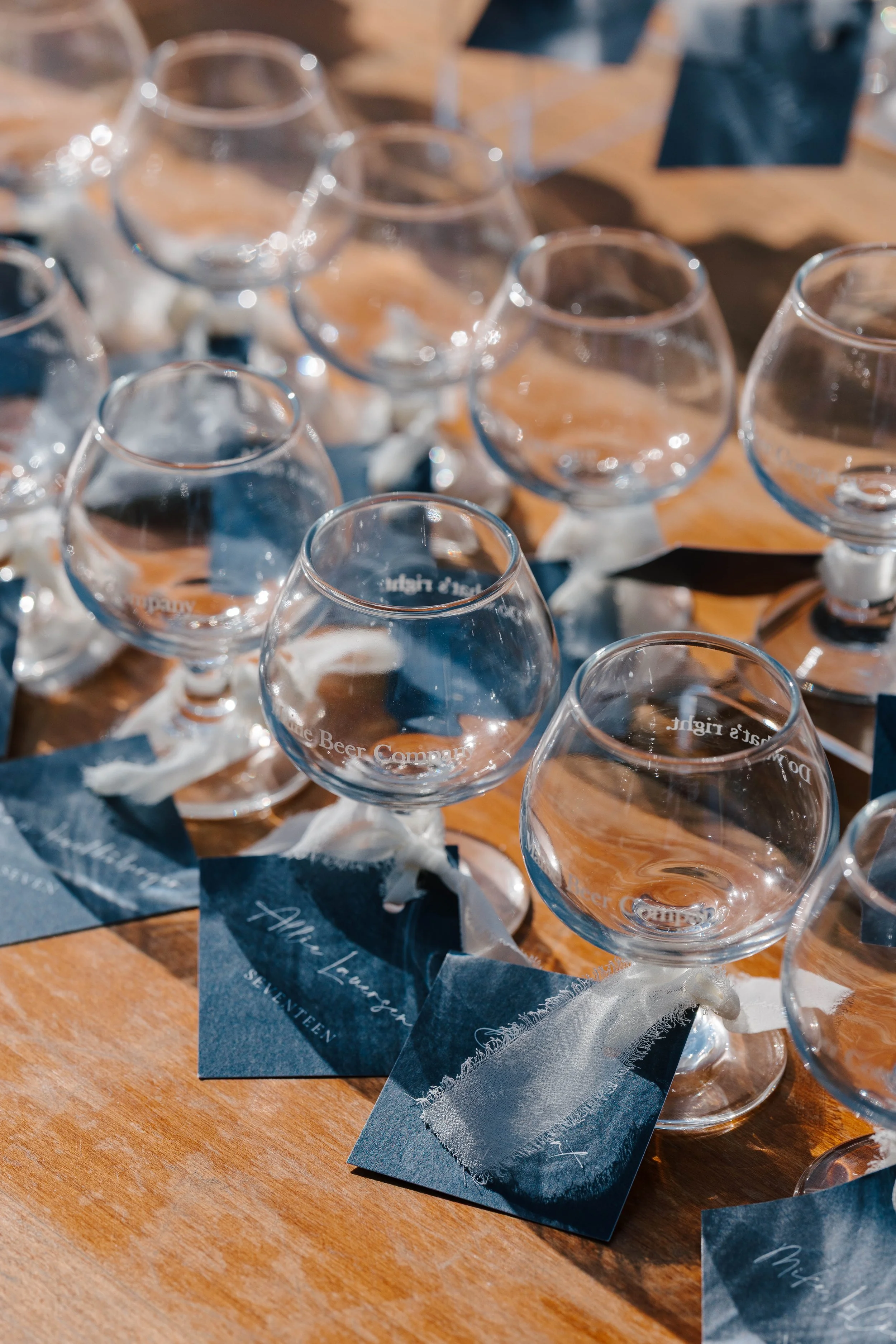 Navy blue wedding escort tags with white typography and chiffon ribbon for a coastal wedding at the Inn at Diamond Cove