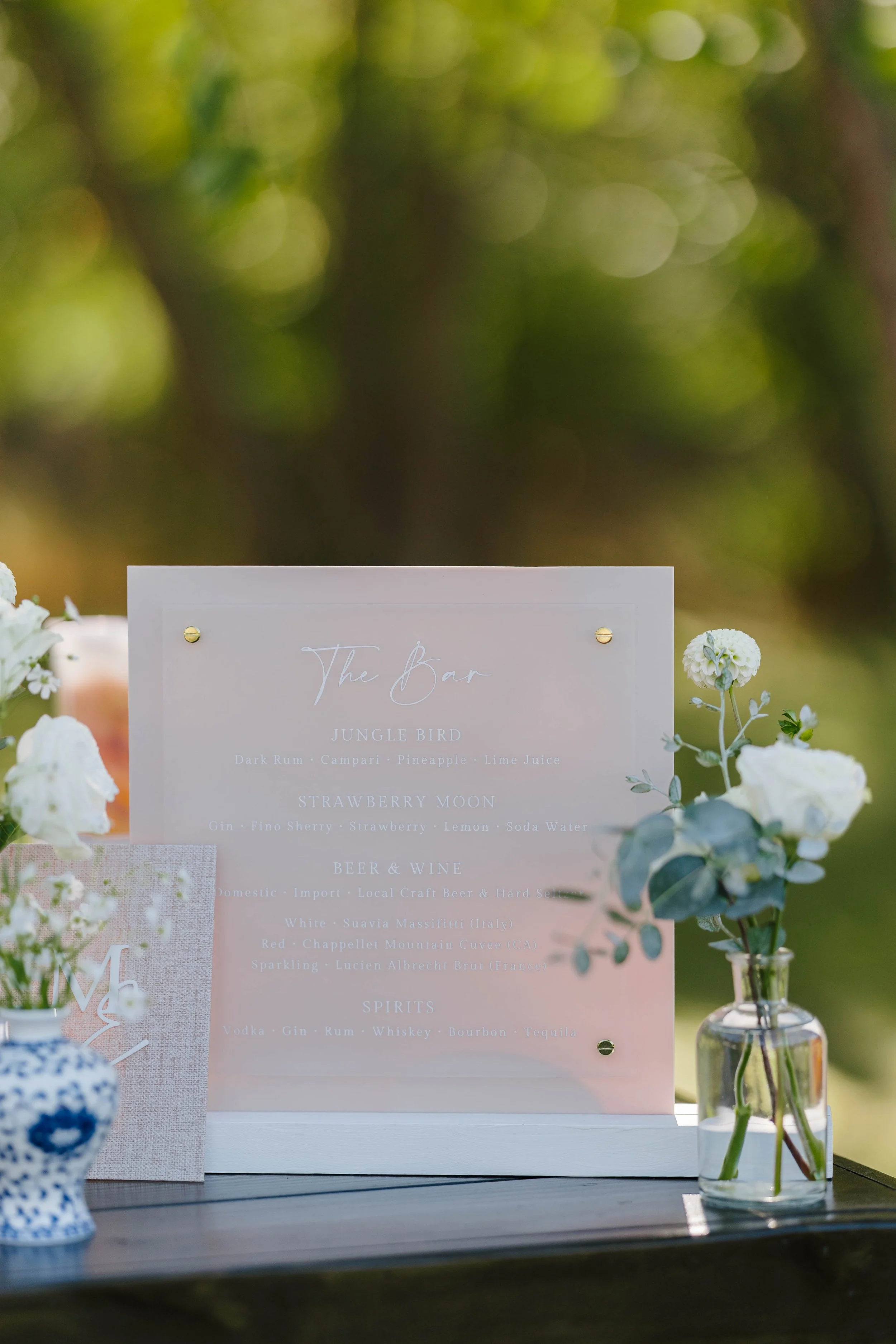 Custom frosted and cream acrylic signature cocktail sign for a wedding reception at the Inn at Diamond Cove