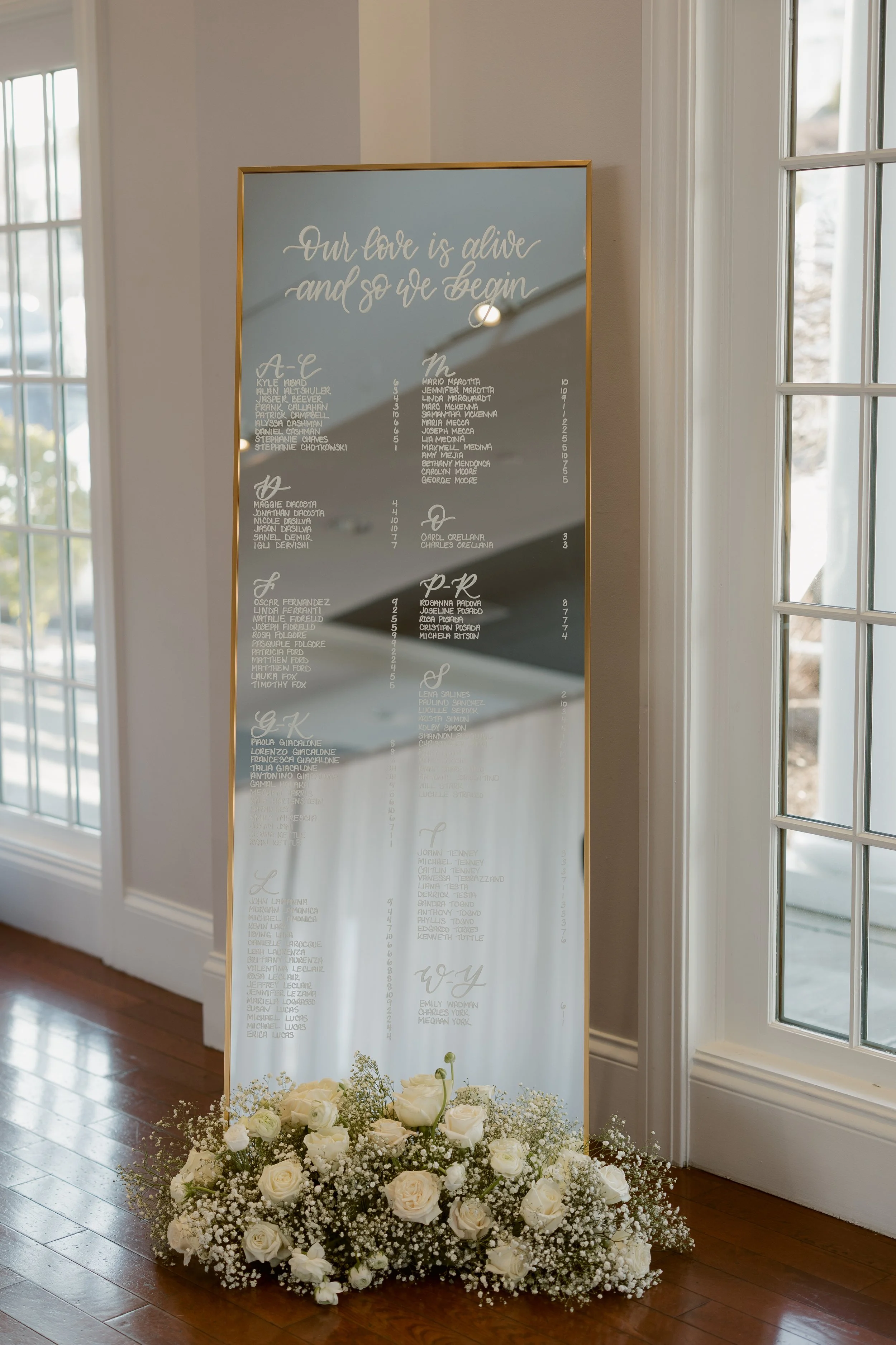 Calligraphy lettered gold mirror seating chart at the Cruiseport Gloucester