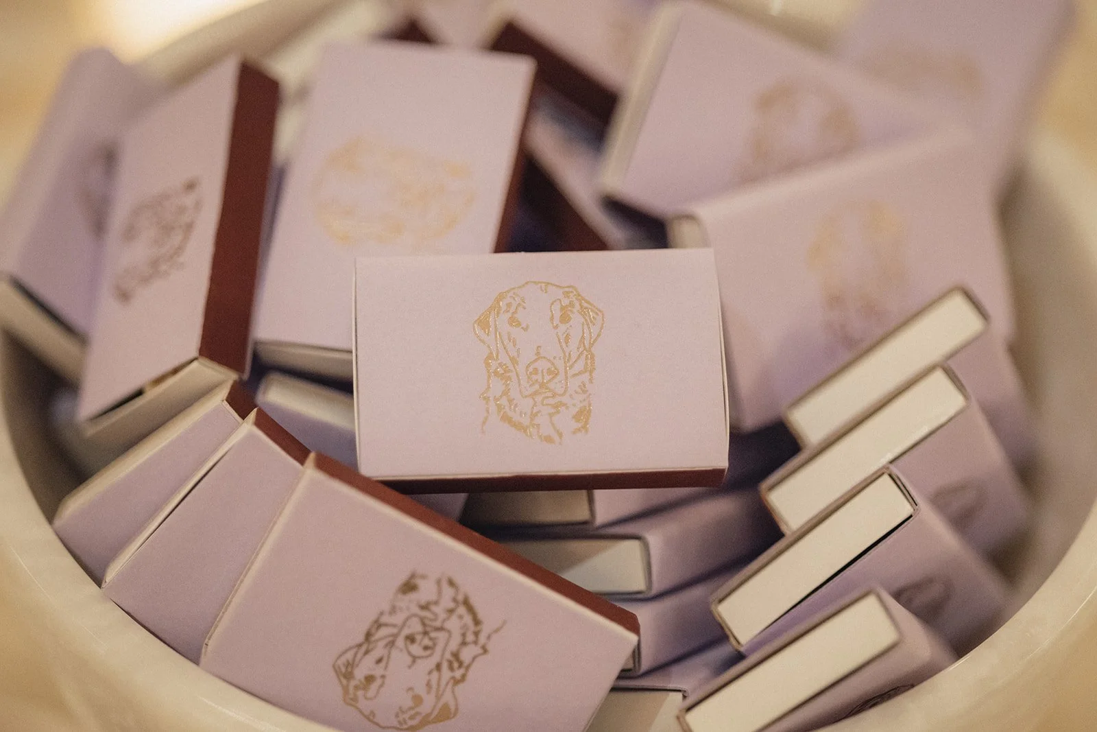 Close-up of small purple match boxes with gold foil dog illustration