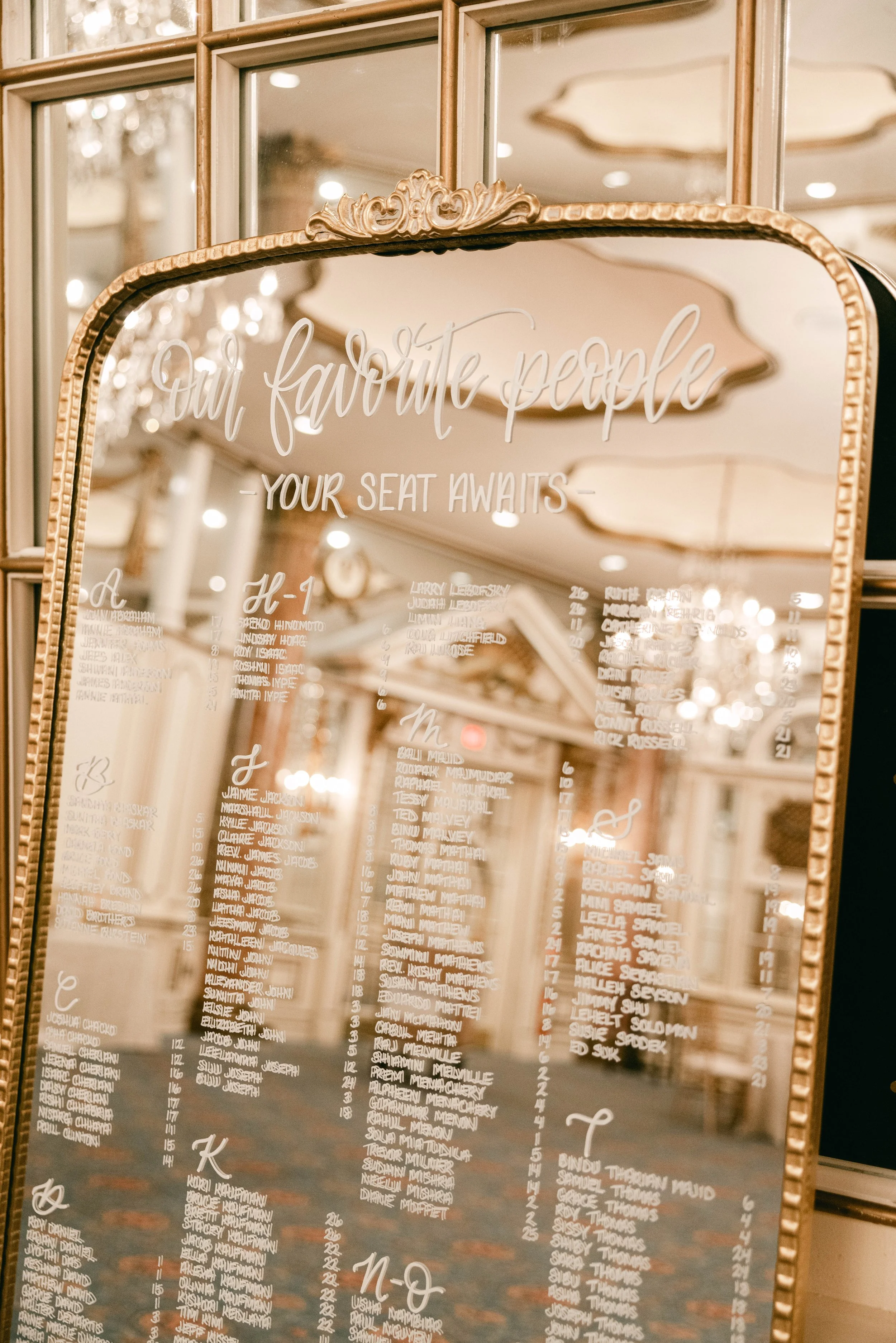 Vintage gold floor mirror with hand-lettered calligraphy seating chart for a classic Boston wedding at the Fairmont Copley Plaza