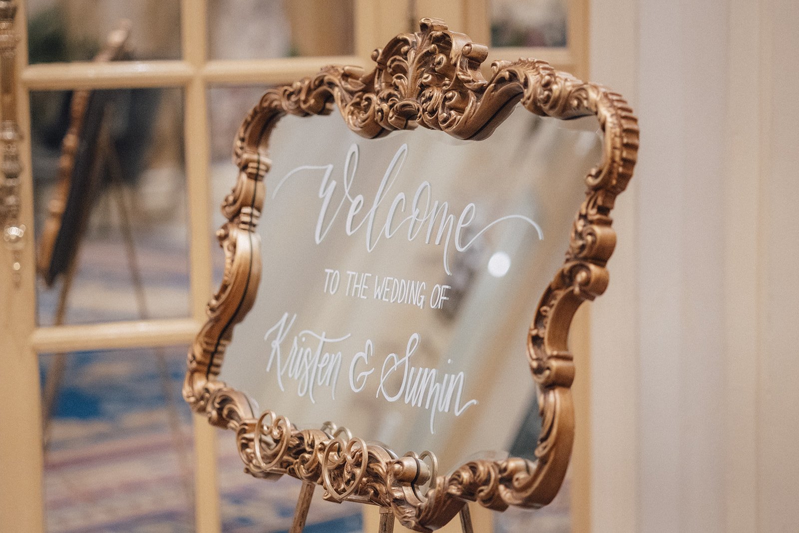 Ornate wedding welcome sign with the text in elegant white calligraphy