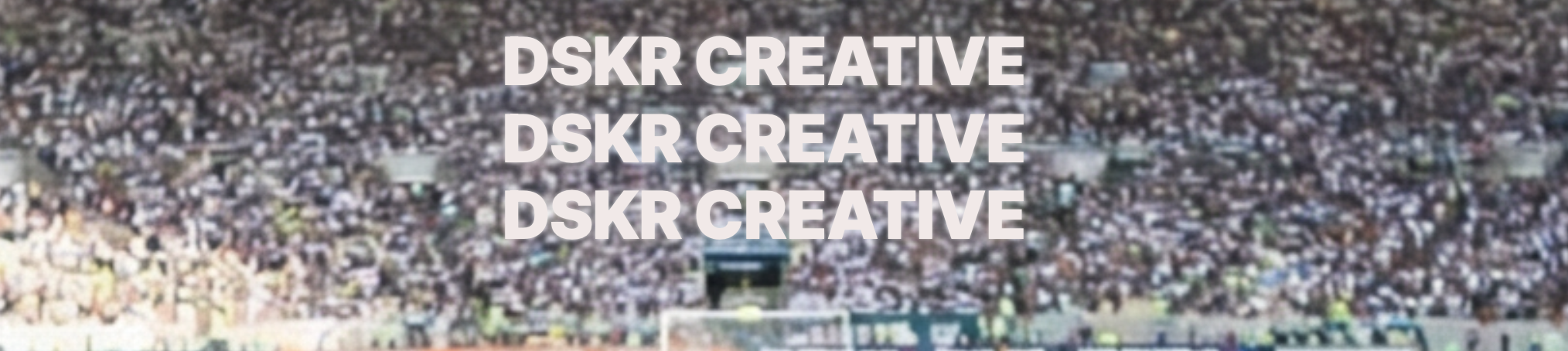 Blurred aerial view of a large crowd at a stadium with six lines of white text: "DSKR CREATIVE" repeated three times, in the foreground.