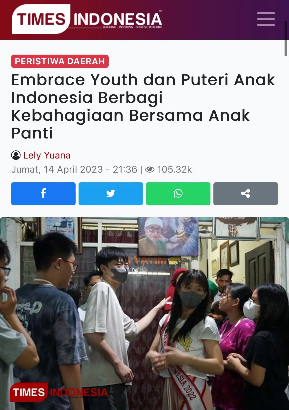 A group of young people, including a young woman wearing a sash that reads "Indonesia 2022," gathered in an indoor setting, wearing face masks, and engaging in conversation. The background features framed pictures and a large portrait.
