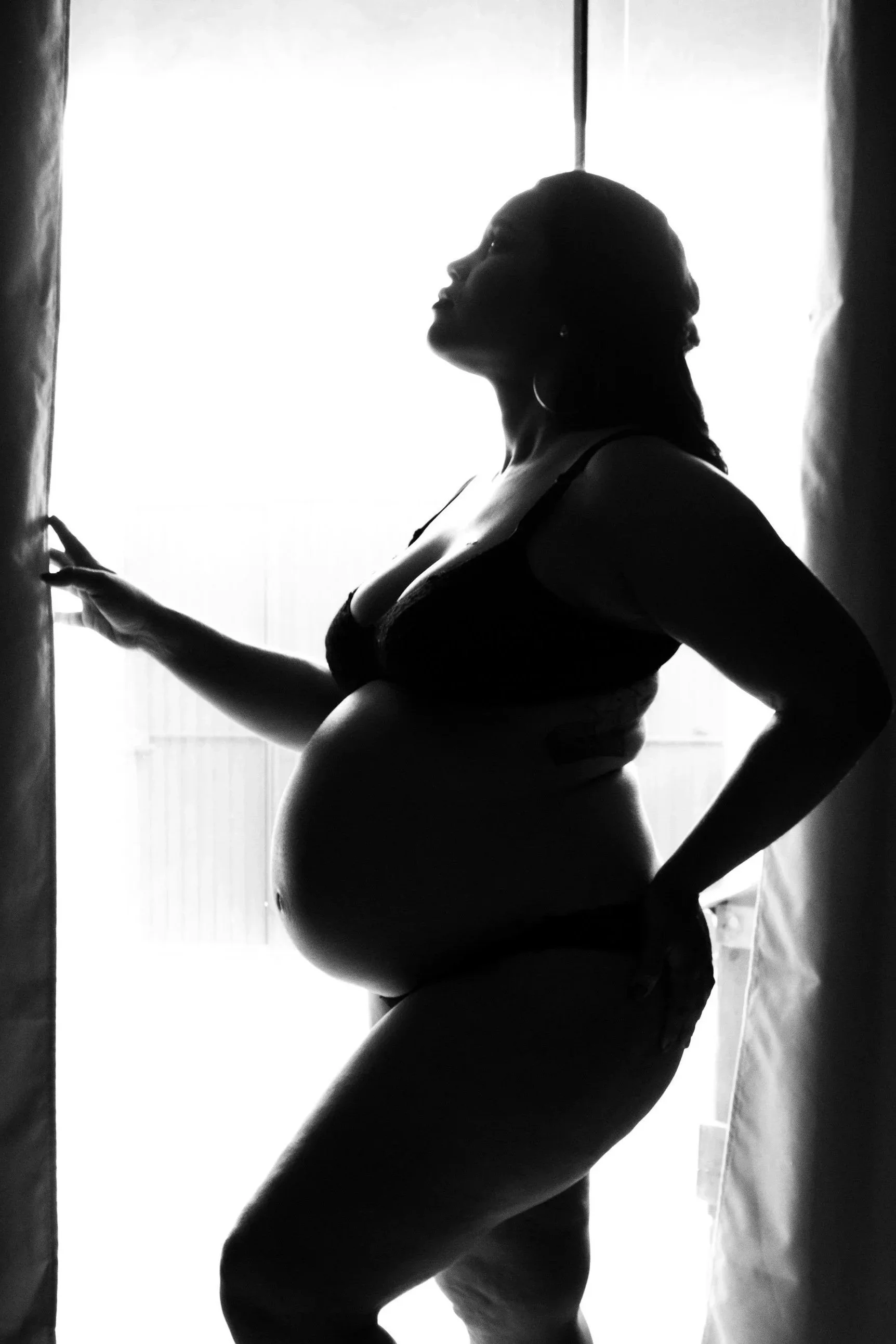 Pregnant woman standing in front of window