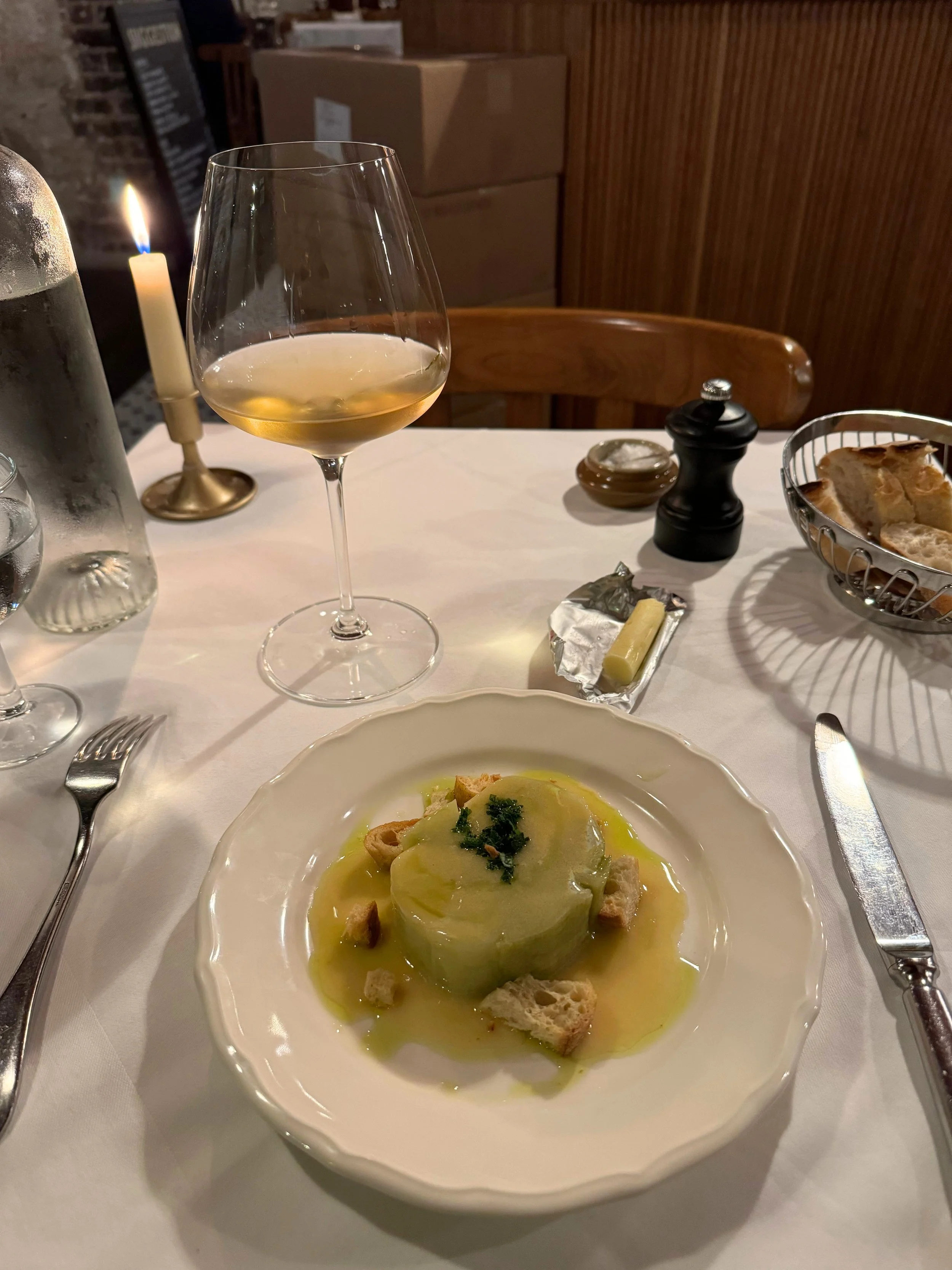 poireaux vinaigrette or leek vinaigrette with croutons on a white table with a glass of white wine