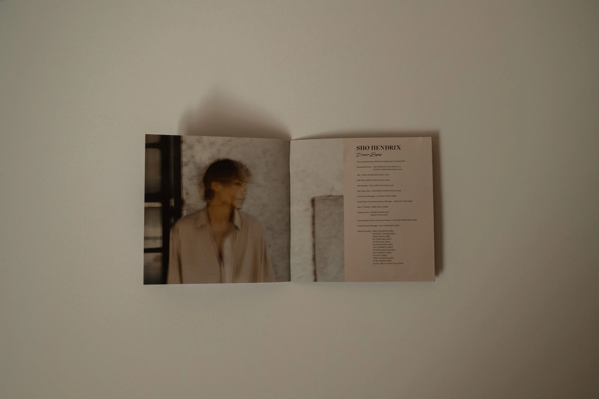 Open booklet featuring an image of a young man on the left page and text about Sho Hendrix on the right page, placed on a light-colored surface.