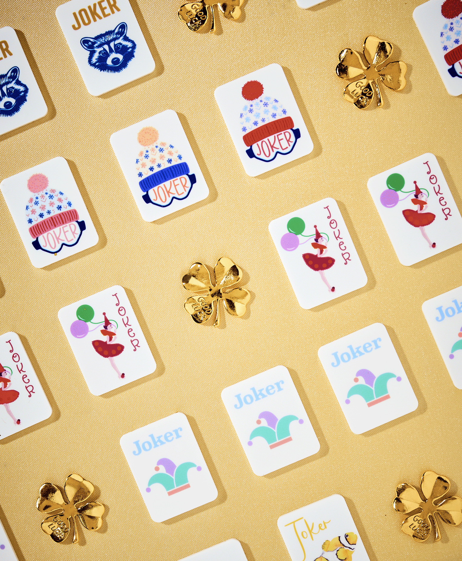 Decorative playing cards with various jokers and gold shamrocks on a gold background.