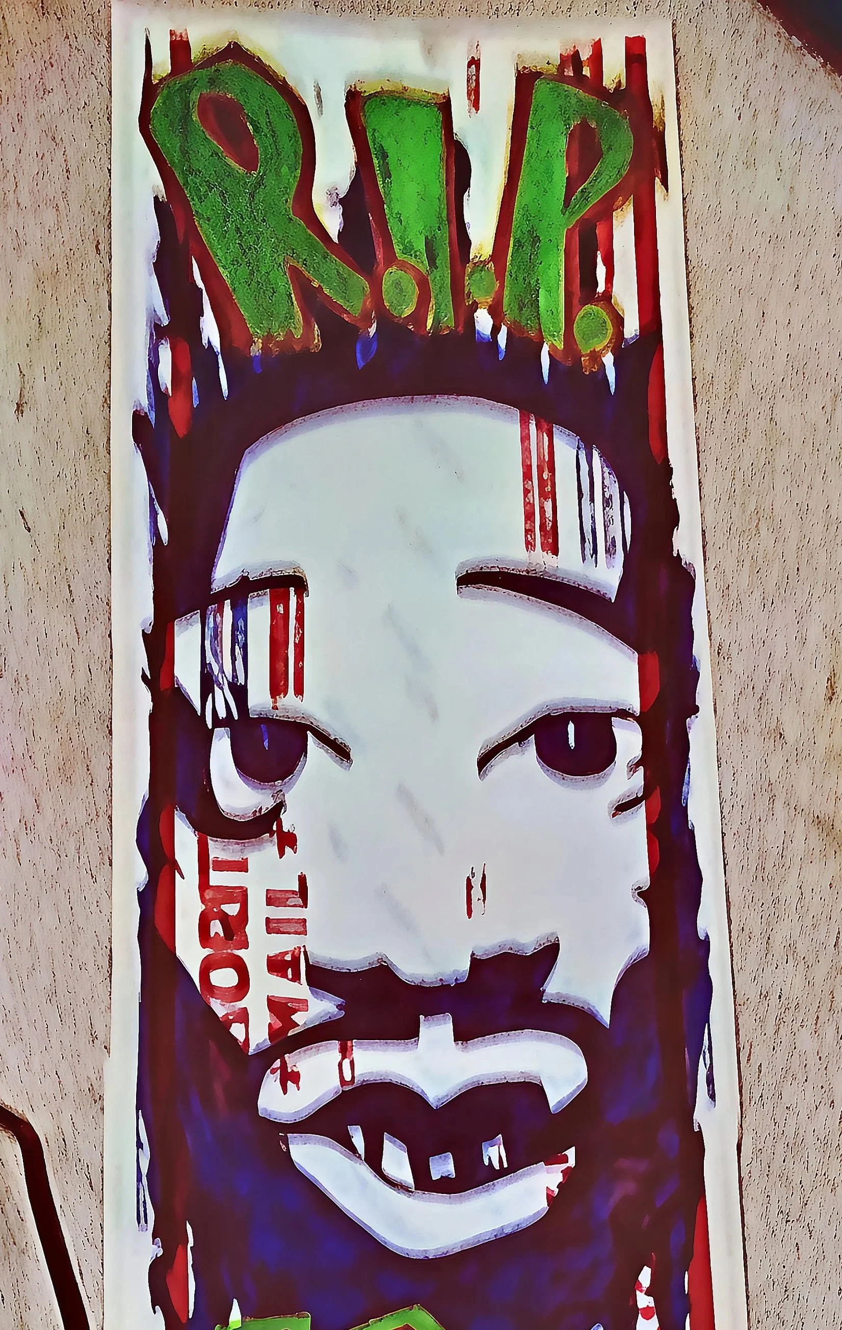 A colorful graffiti art piece depicting a stylized face with eyes and mouth, and the word 'RIP' in green and red letters at the top.