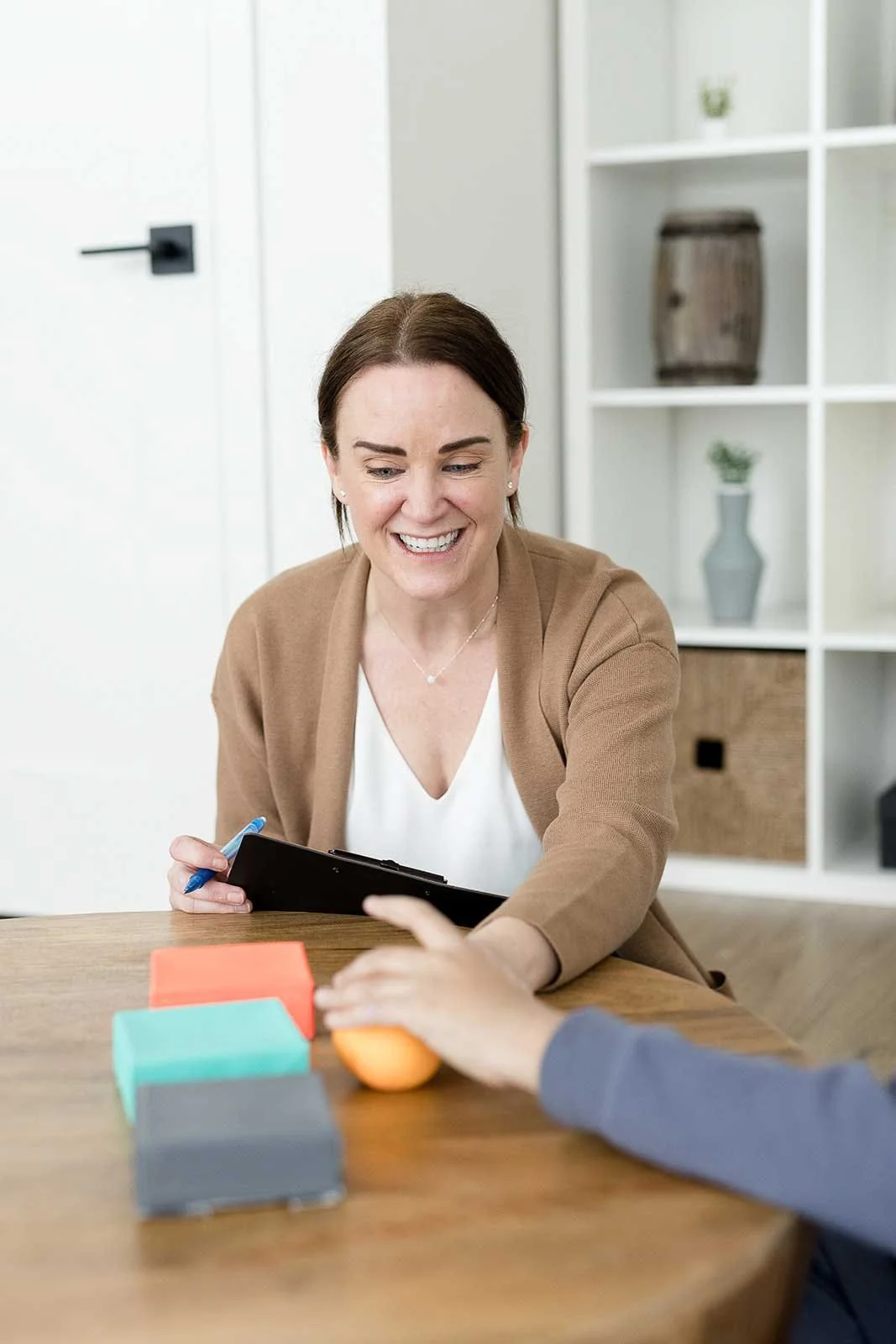 Psychologist supporting a child with executive functioning skills during therapy at Ten Child Psychology in Calgary