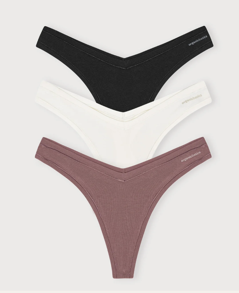 Three women's thong underwear in black, white, and mauve colors stacked vertically against a gray background.