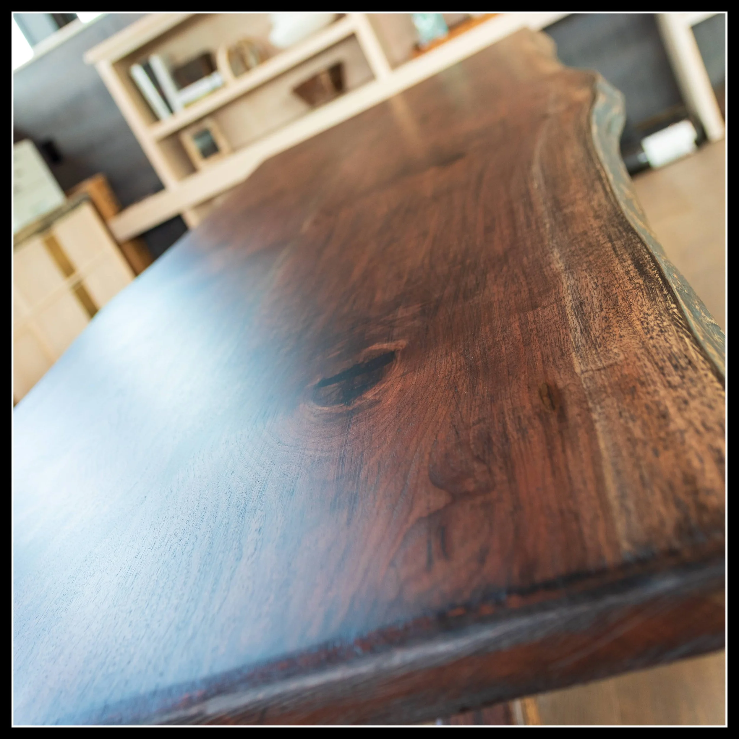 Hand‑scraped solid walnut live‑edge desk top with aged textured finish and natural hardwood grain.