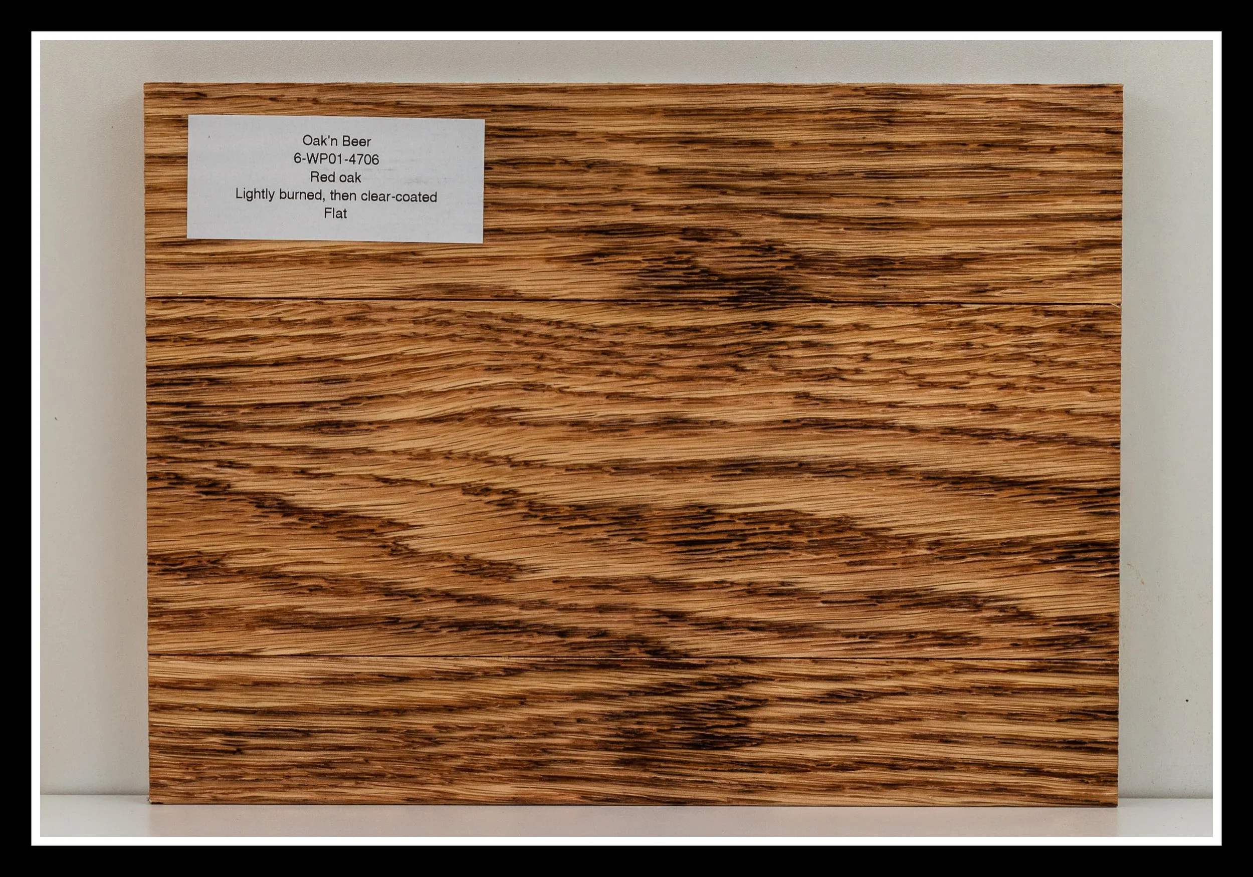 Close‑up of red oak wood grain with deep brushing, light burn, warm glaze, open pores, and a satin 2K poly finish.