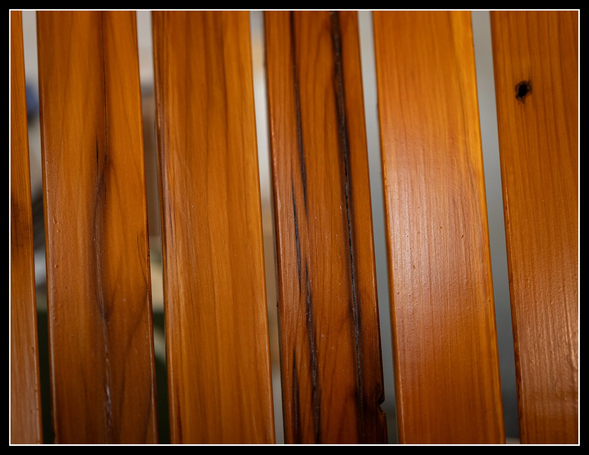 Close-up of three vertical wooden slats in a honey-colored finish.