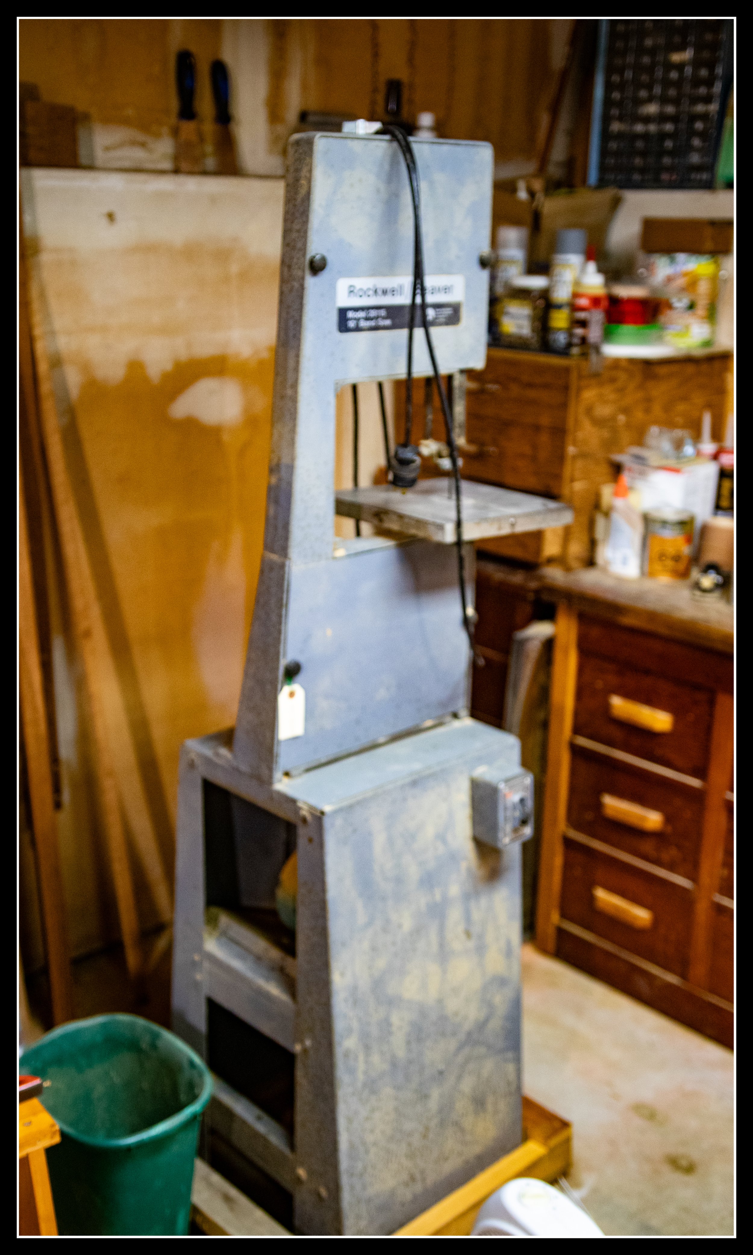 Vintage Rockwell Beaver 10-inch bandsaw from the 1950s, showing its cast-iron frame, metal base, and original induction motor in a workshop setting.