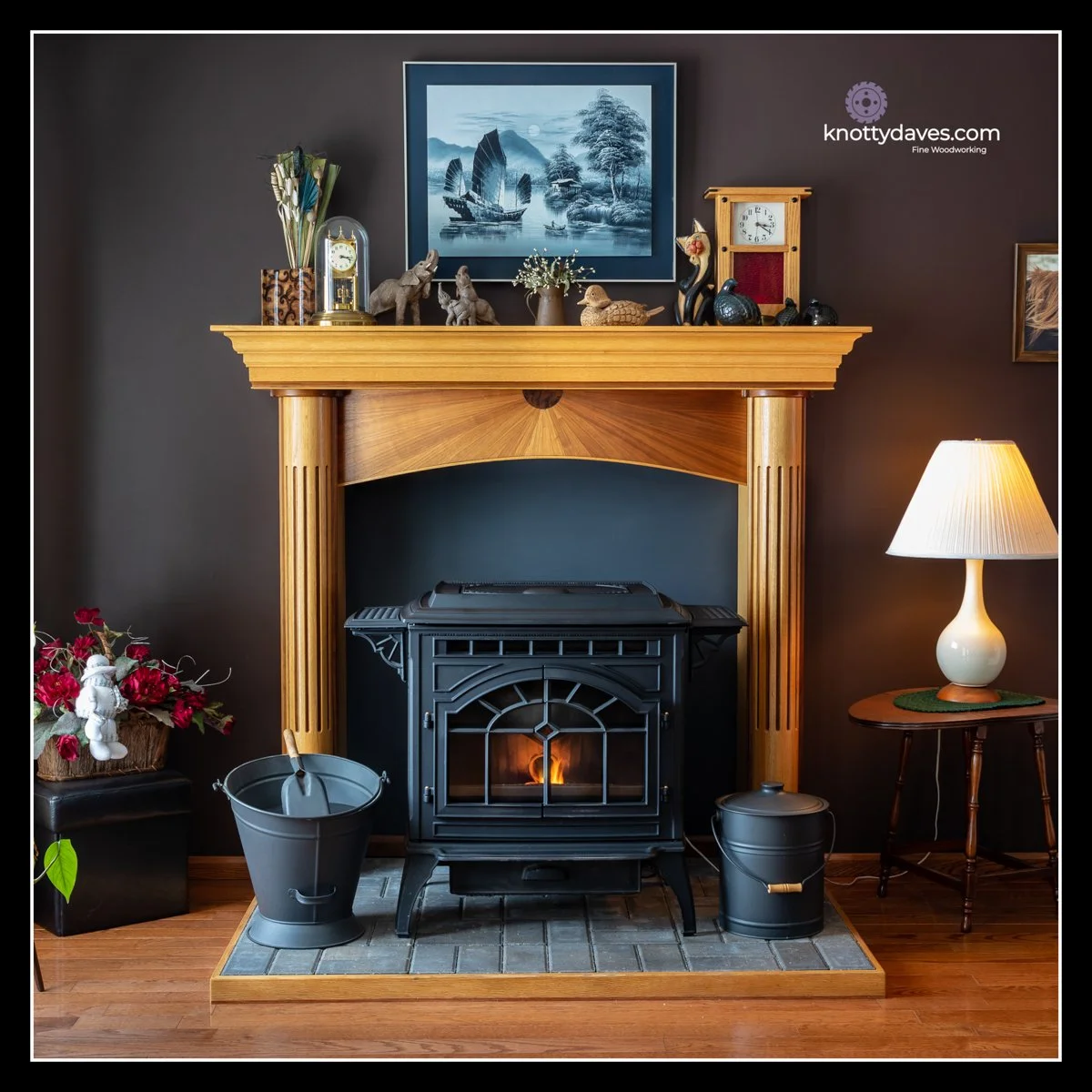 Red oak and walnut mantel with veneered starburst arch, fluted oak columns, walnut inlay, and cast‑iron stove hearth.