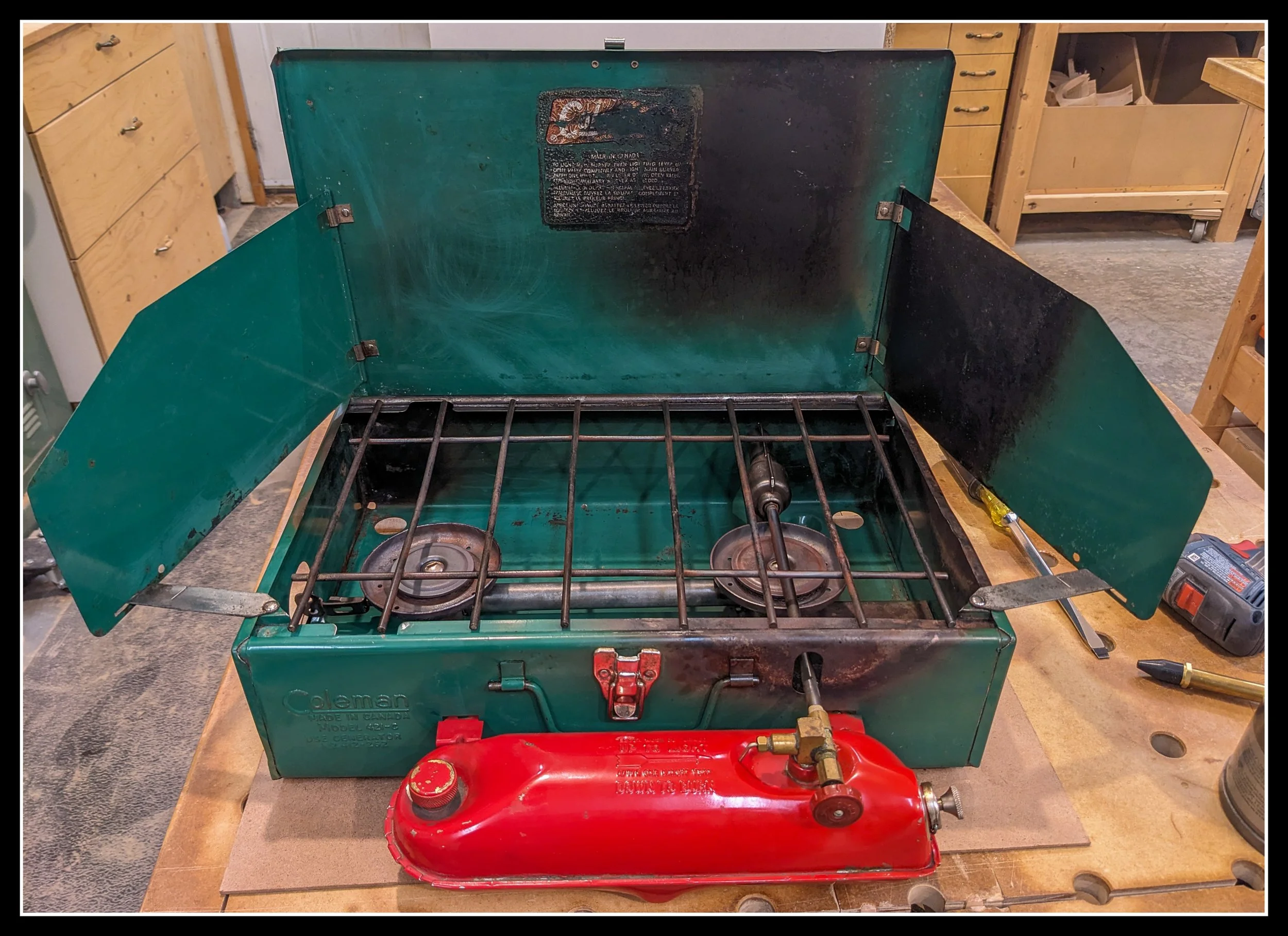 Vintage Coleman two‑burner stove restored and running again, symbolizing memory, repair, and the personal parallel between fixing old tools and facing changing health.