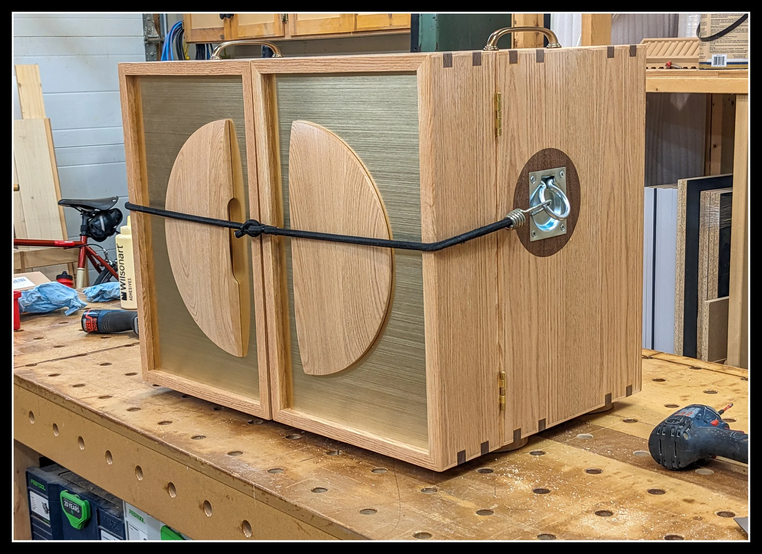 Hand‑built Mini Kitchen cabinet on a workbench, showing the turned front panel used as a door pull.