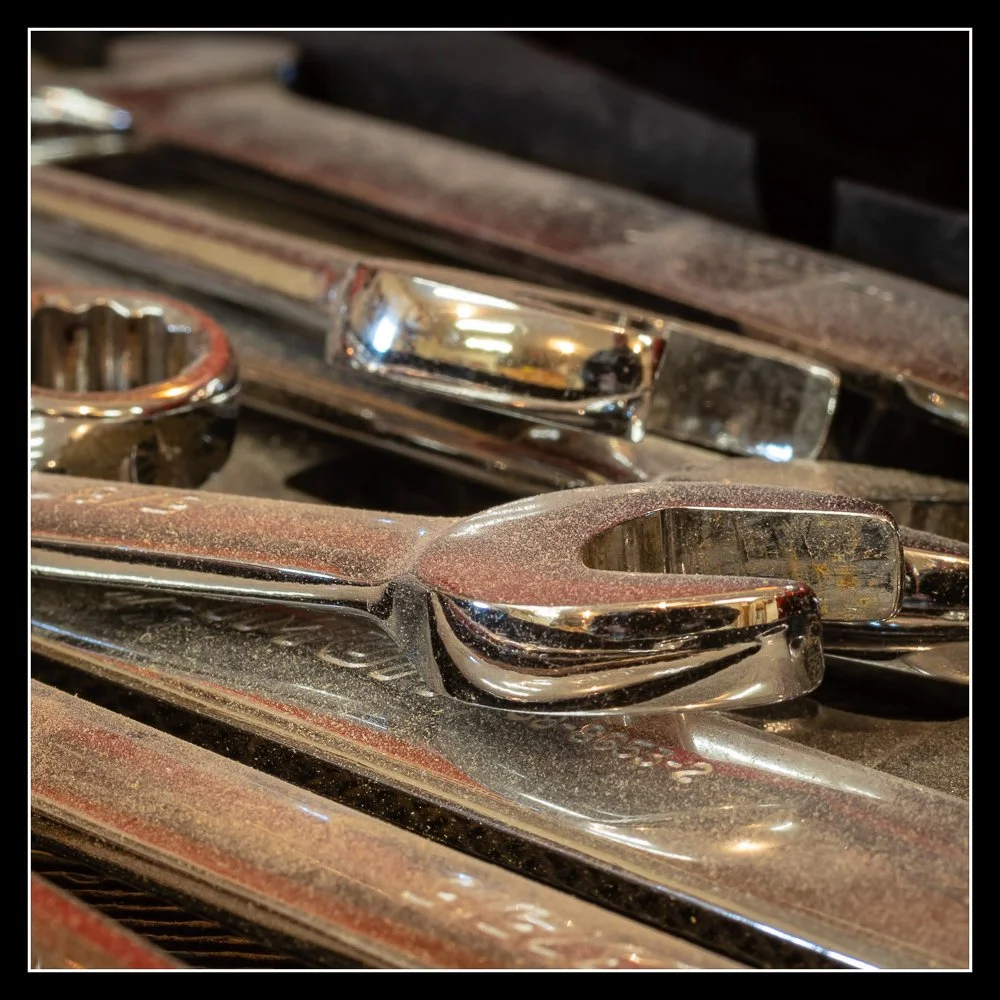 Dust‑covered wrenches and spanners in the shop, symbolizing the start of a new chapter at Knotty Dave’s.