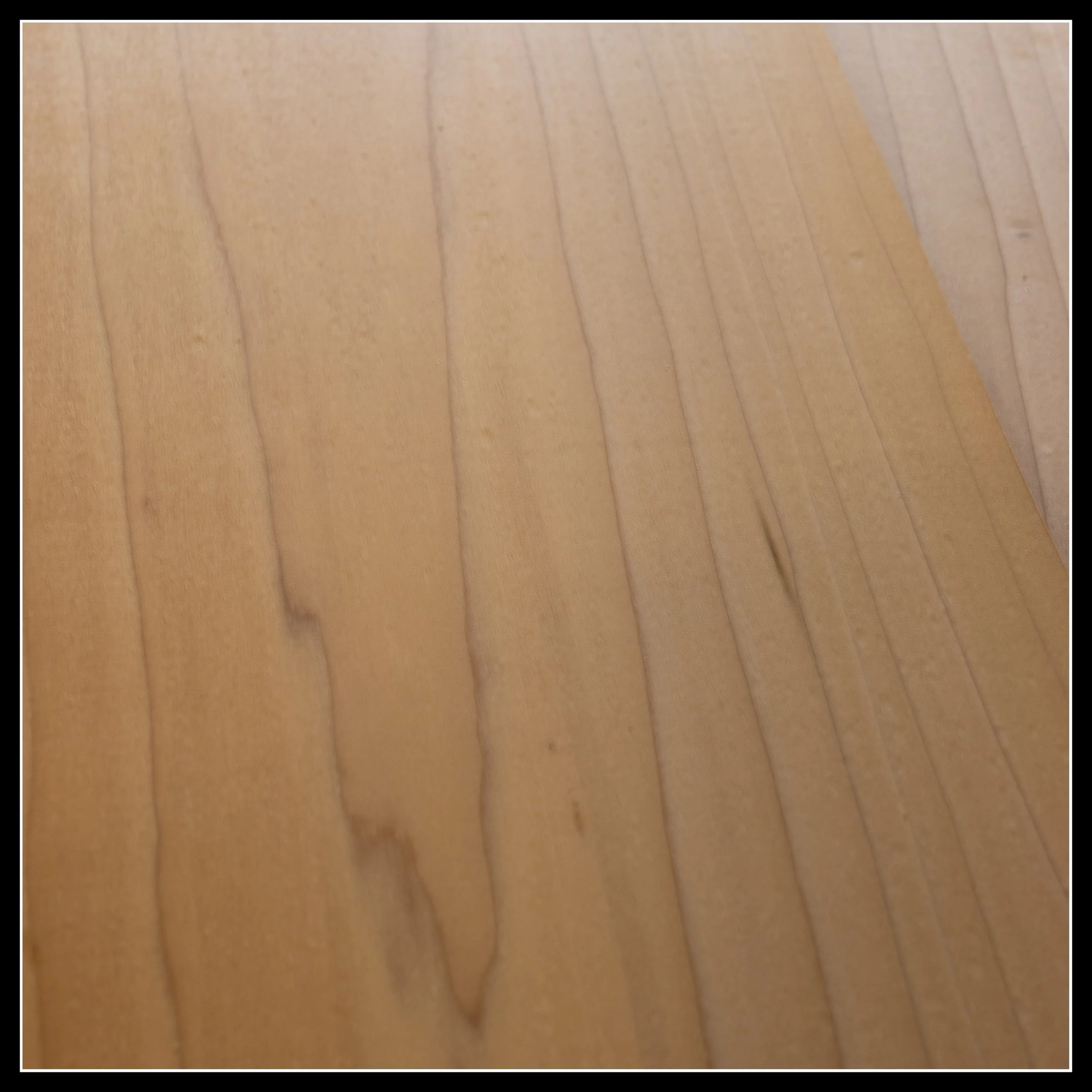 Close‑up of poplar wood grain showing pale tan colour with subtle green and purple undertones.