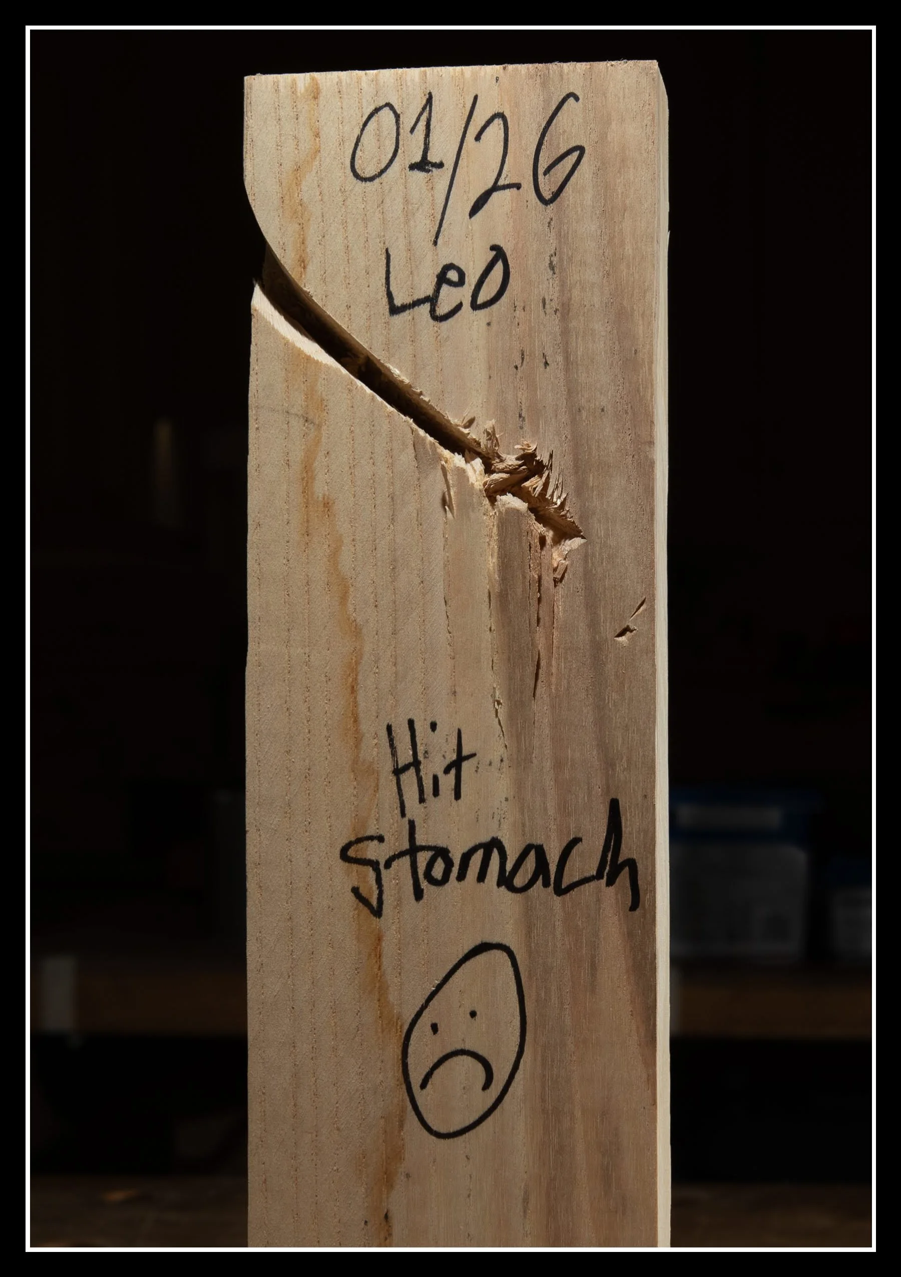 Wood board with a kickback dent and handwritten notes marking the incident, showing a real shop moment and the unexpected mishaps of woodworking.