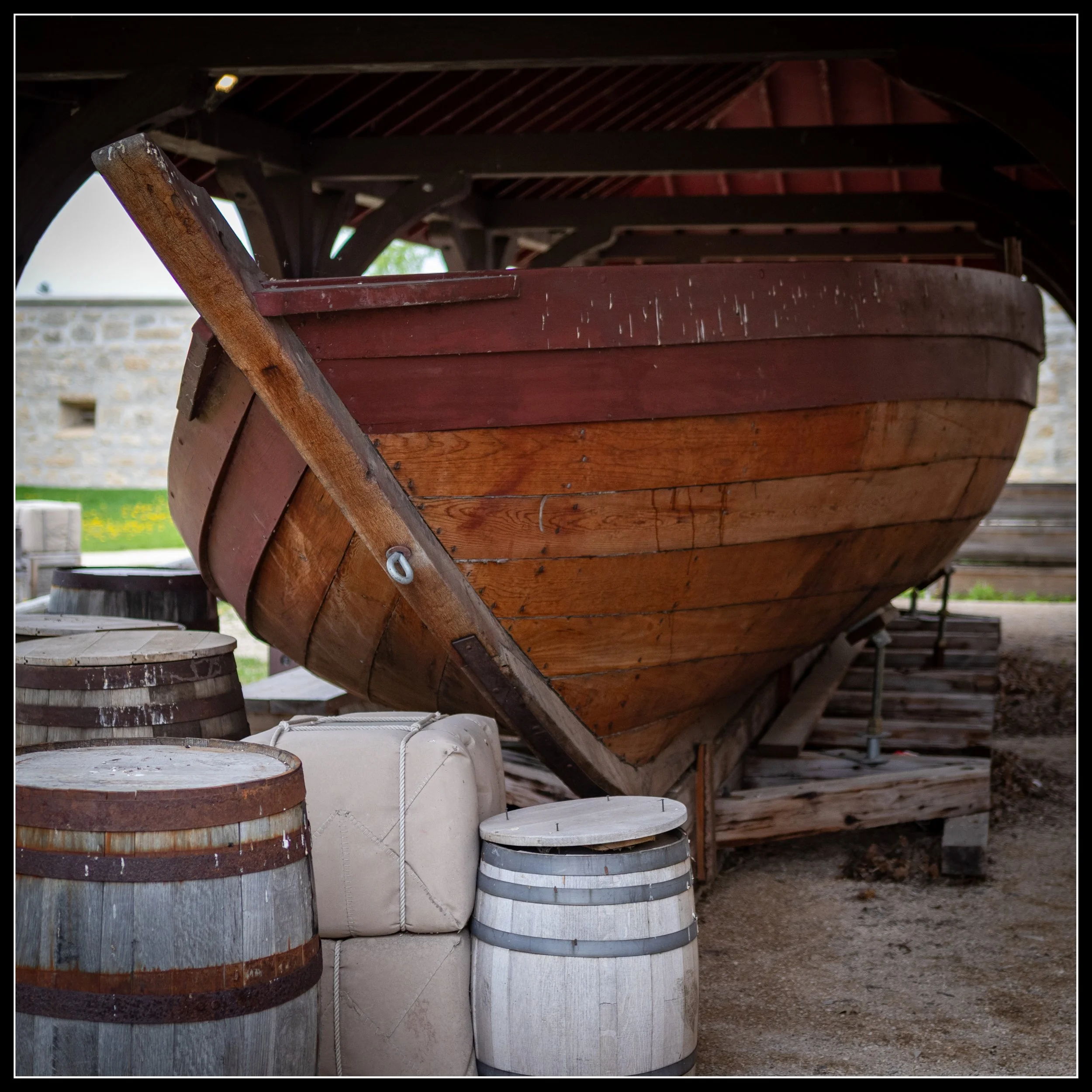 York boat under shelter with wooden barrels and supplies, showing traditional fur‑trade era construction and representing the story “The Value of Wood.”