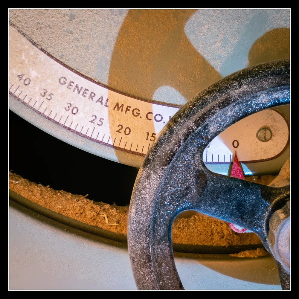 Close‑up of a General 350 cabinet saw tilt gauge and cast‑iron handwheel showing precise bevel adjustment, heavy‑duty construction, and professional woodworking machinery.