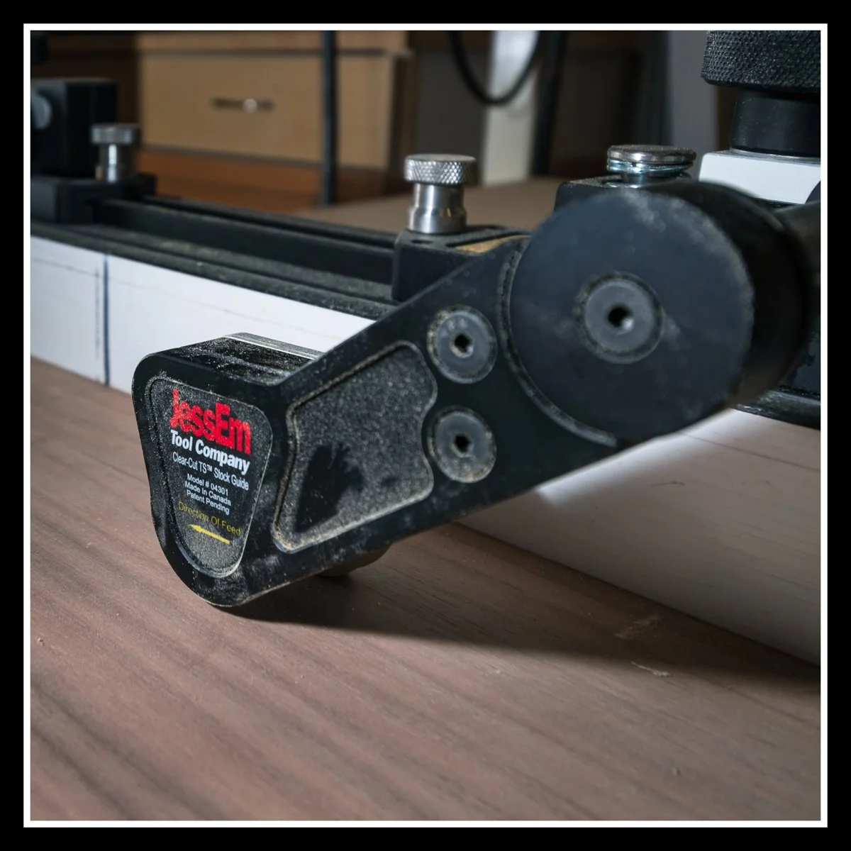 JessEm Clear‑Cut TS Stock Guides mounted on a table saw fence, showing forward‑rolling wheels, anti‑kickback action, and precision woodworking support.