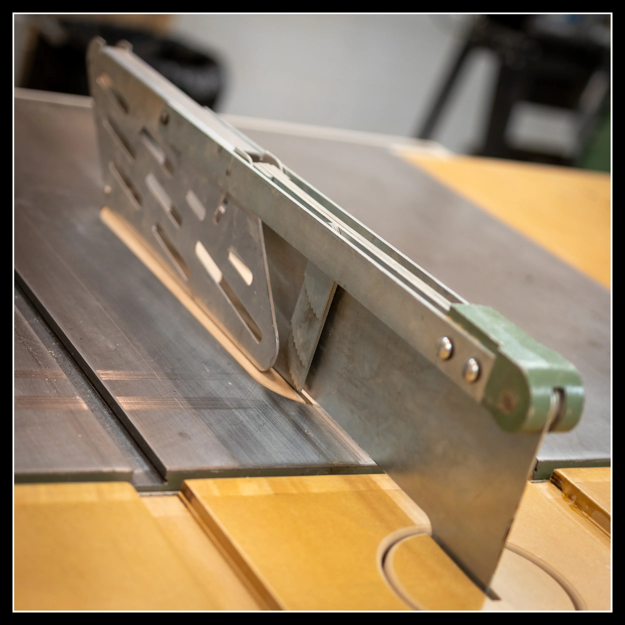 Original General table saw splitter and steel blade guard with cast‑iron mounting and kickback dogs, showing heavy‑duty safety hardware on a vintage Canadian cabinet saw.