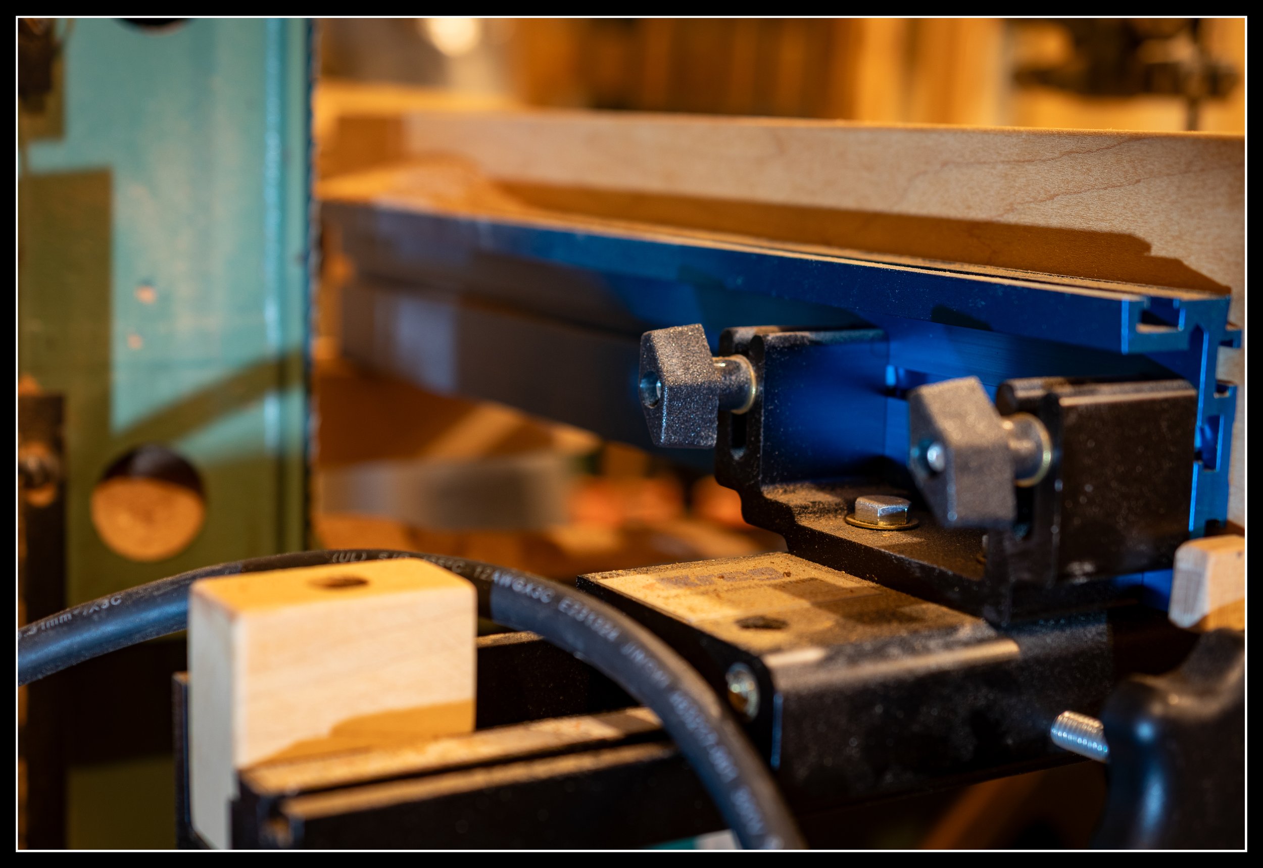 Close-up of a Kreg aftermarket bandsaw fence installed on a General 490 15-inch cast‑iron bandsaw, showing the precision fence setup and alignment hardware used for accurate woodworking cuts.