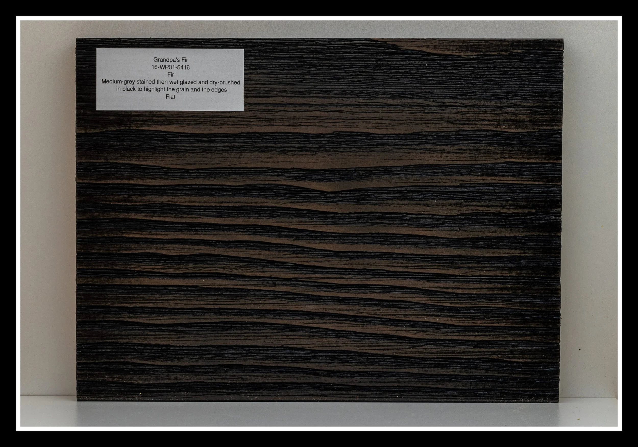 Douglas Fir finish sample labeled “Grandpa’s Fir,” showing medium brown stain with wet glazing and black dry brushing to highlight fir’s grain pattern.