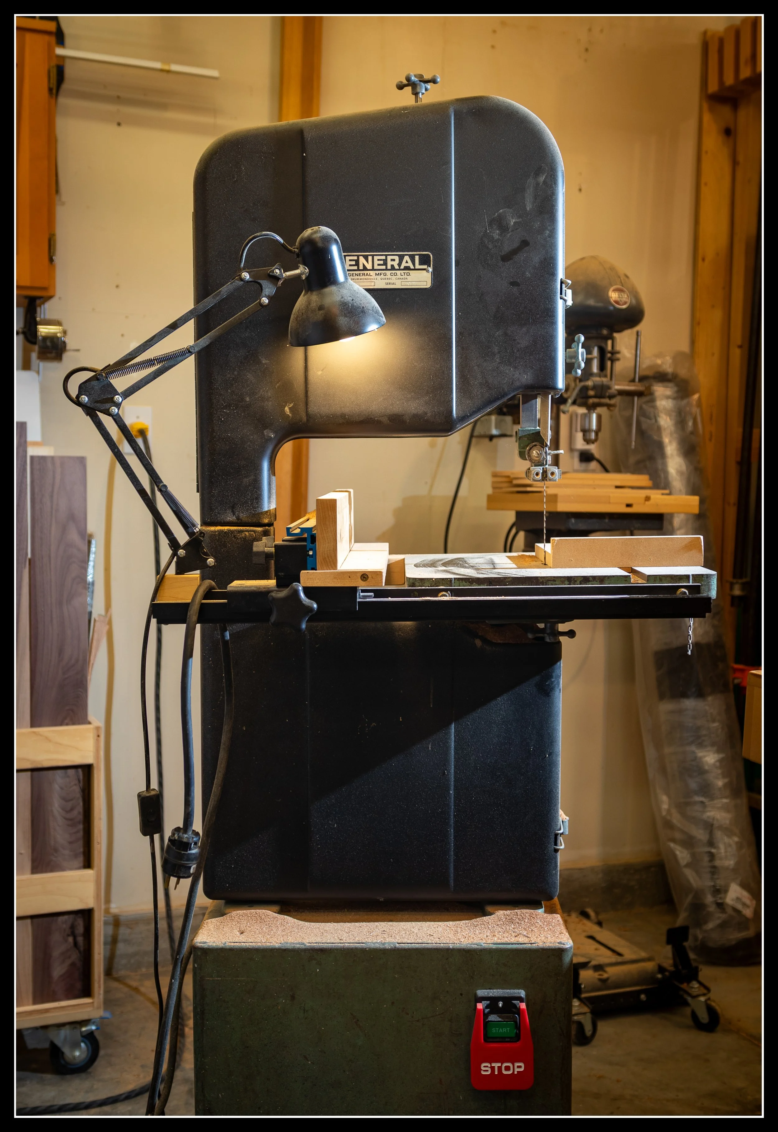 General 490 15-inch Canadian-made bandsaw from the 1980s, shown with cast-iron frame, aftermarket fence, and shop lighting in a woodworking environment.