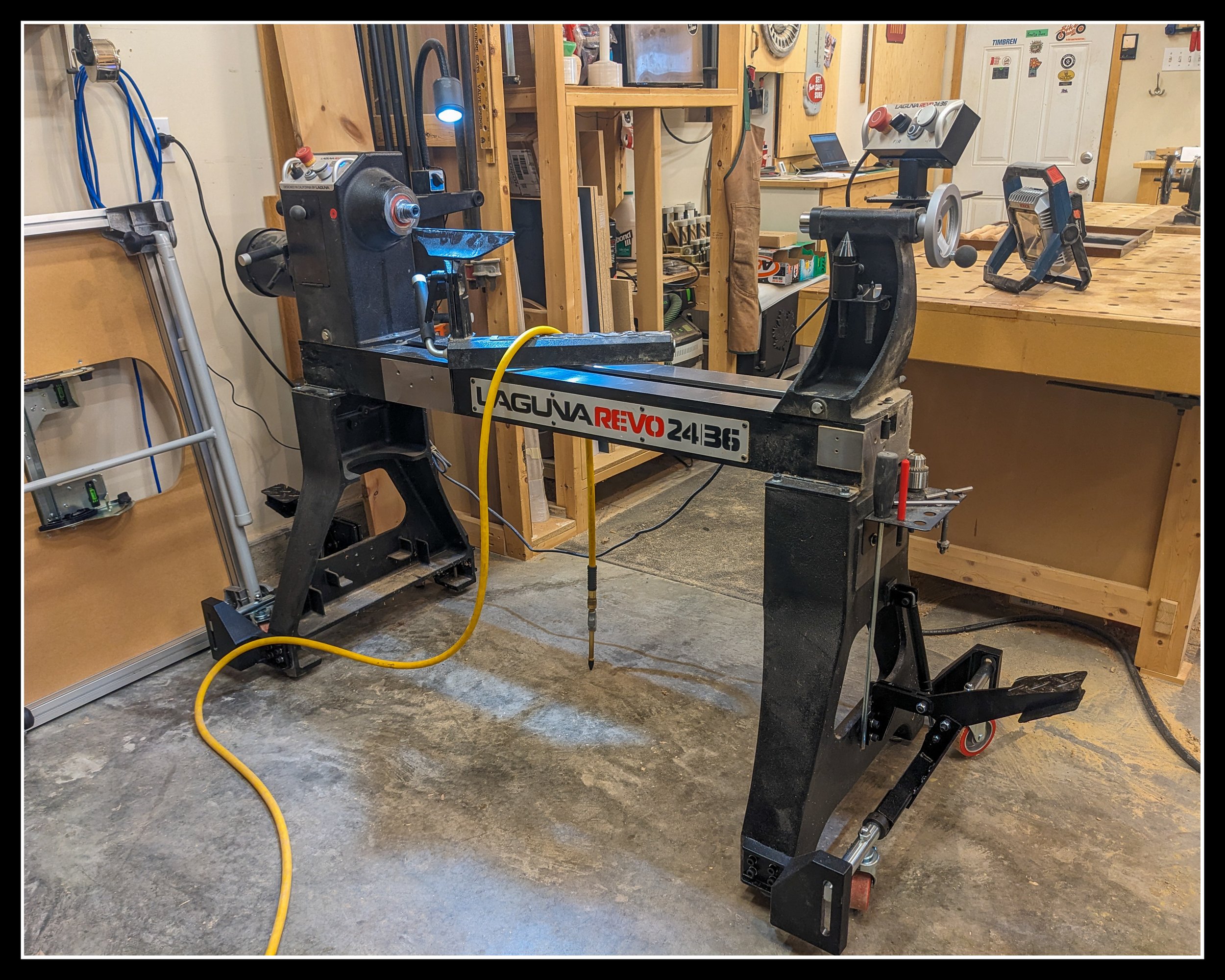 Laguna Revo 24|36 woodworking lathe with mobile kit installed, shown in a workshop setting with tools and air hose nearby, highlighting its size, stability, and professional turning capability.