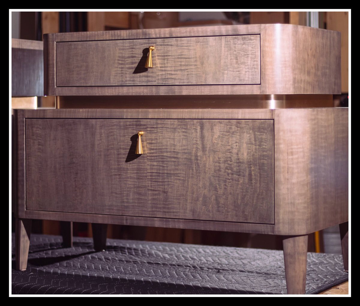 Wood nightstand on a black blanket, lit with side and subtle back flashes to highlight grain, shape, and brass pulls.
