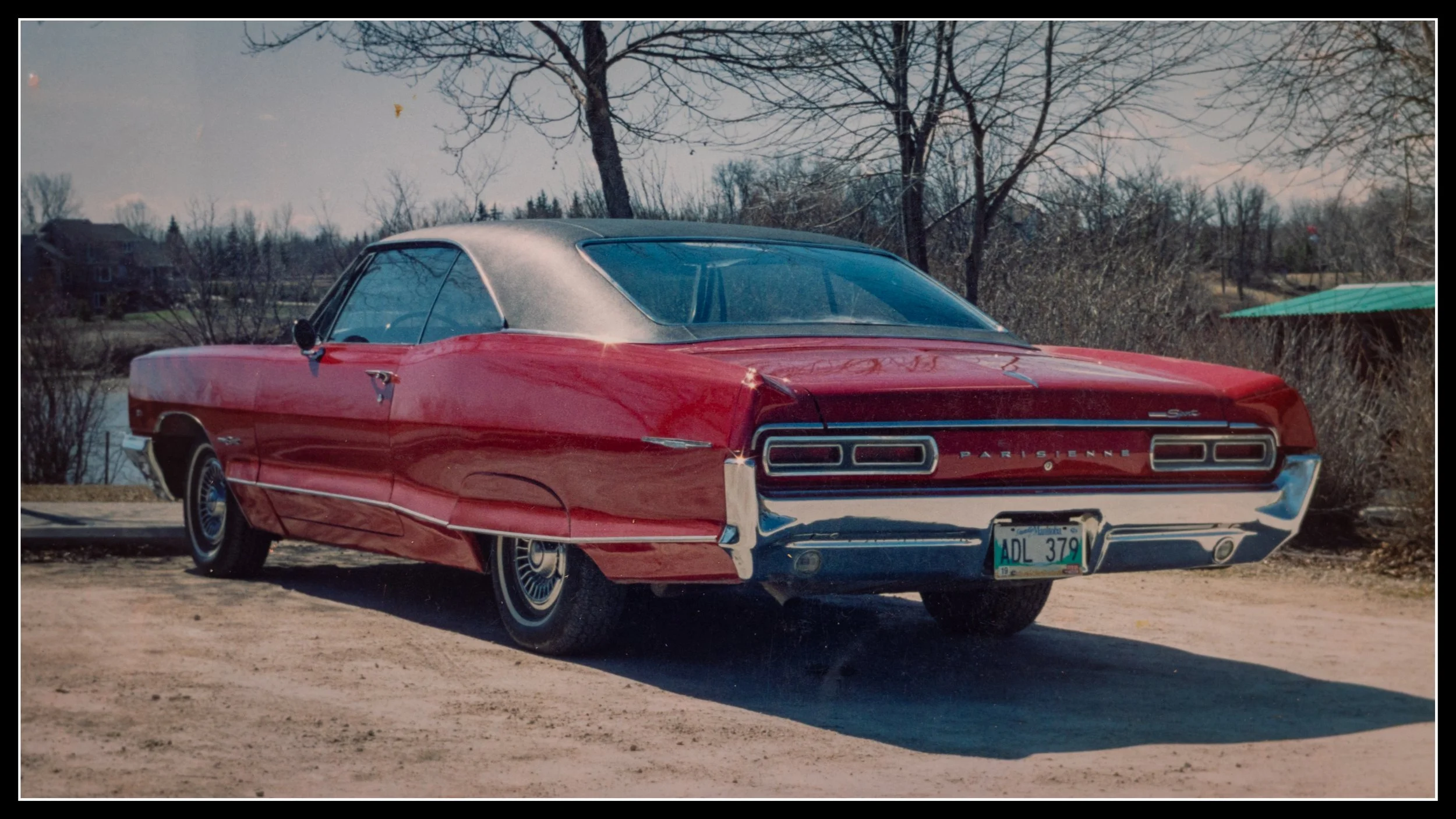 Rear view of a restored 1966 Pontiac Parisienne Custom Sport, Canadian model, parked near water with chrome bumper, vinyl roof, and classic tail lights.