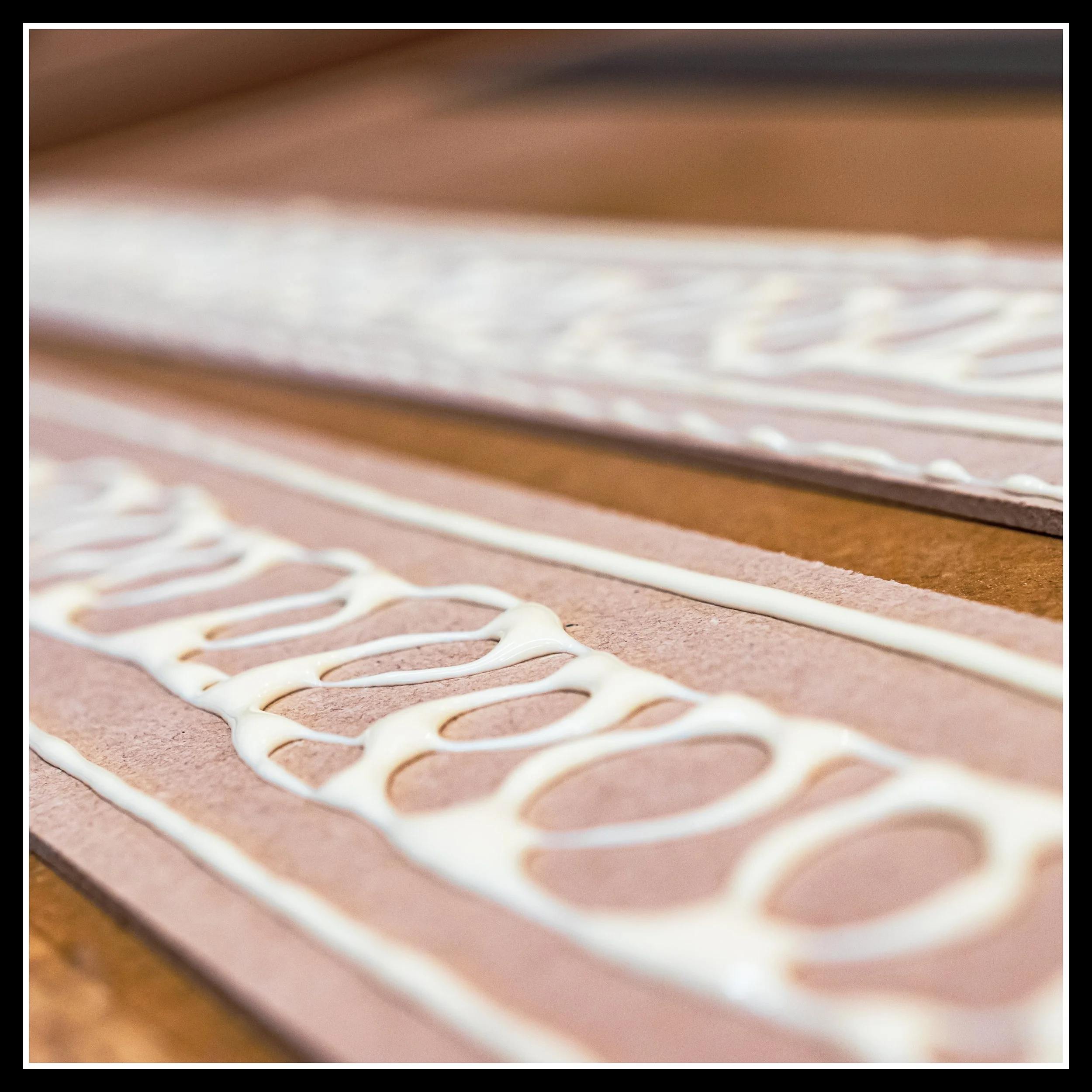 Two MDF pieces on the bench with yellow wood glue applied in wavy beads along the length.