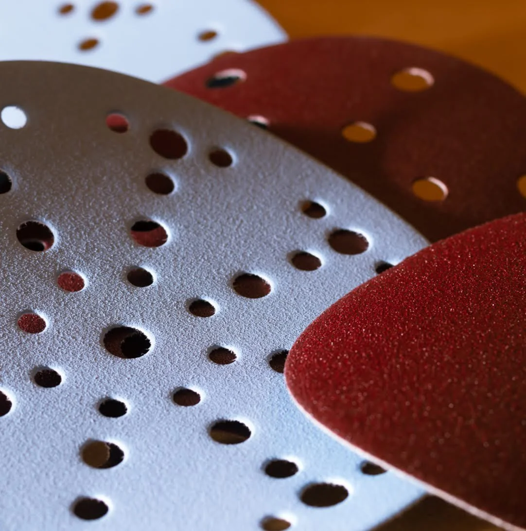 6-inch Festool-compatible sanding discs with multi-hole dust-extraction pattern on a woodworking bench