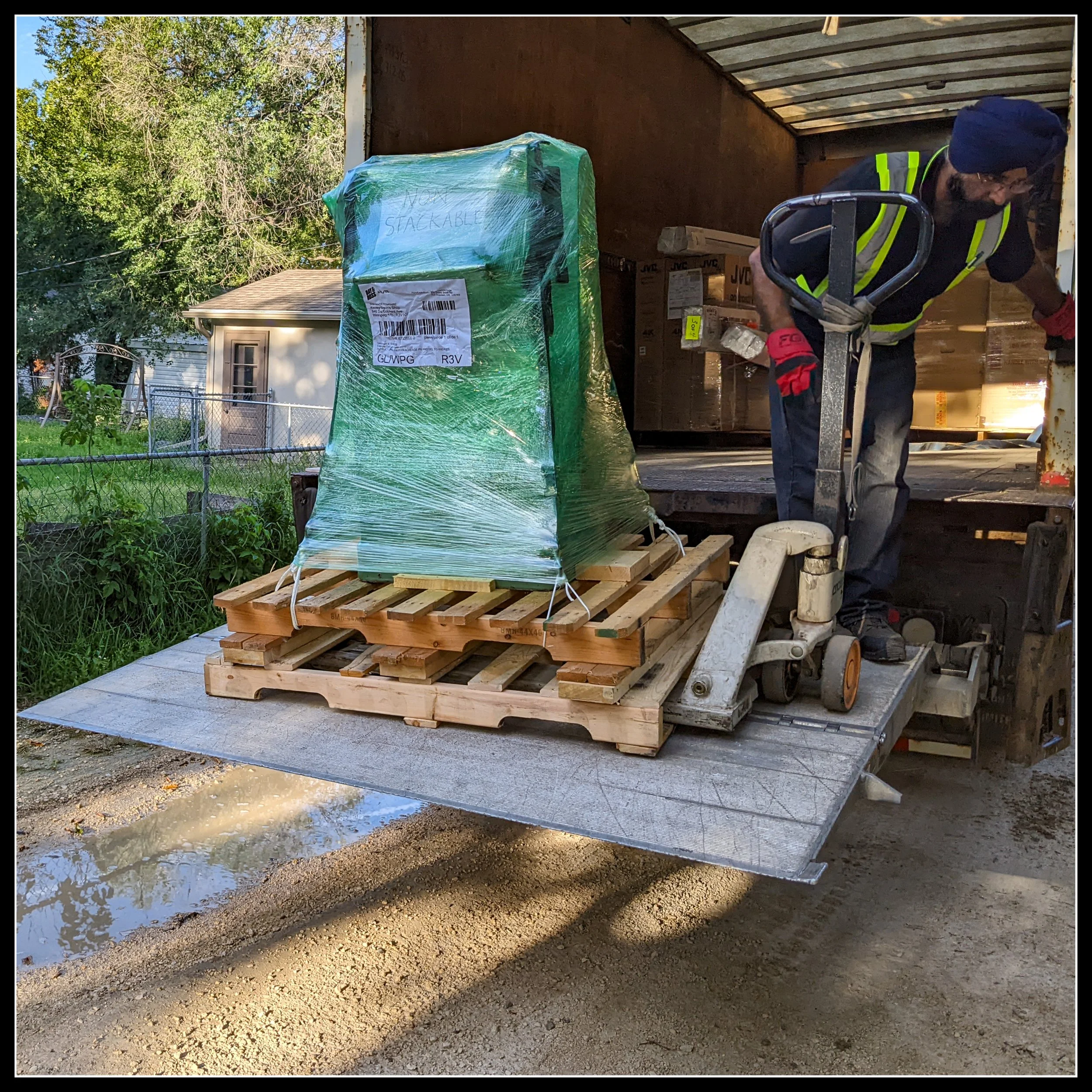 General 130 thickness planer being unloaded from a truck on a pallet jack in fall 2022, marking a milestone delivery during the early signs of the user’s cancer journey.