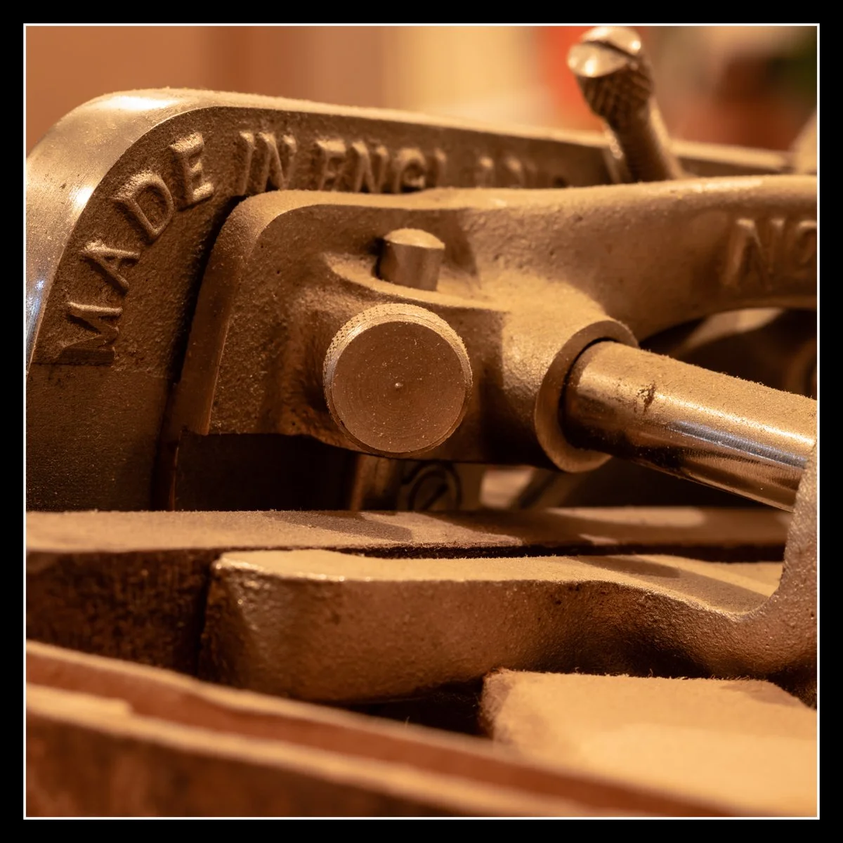 Vintage Record No. 050 grooving plane stamped “Made in England,” showing metal body, bolts, and rod assembly in a woodworking shop.