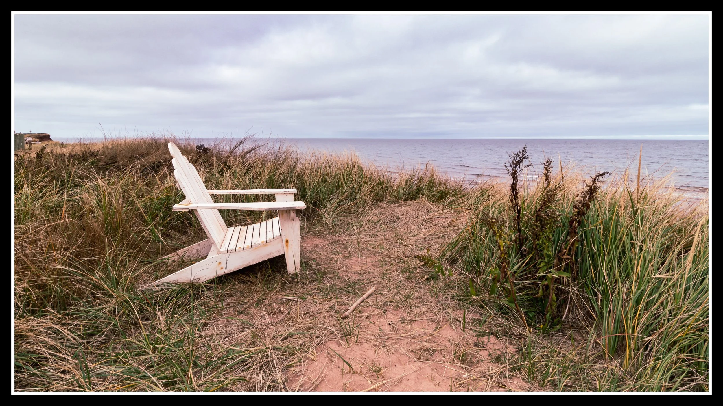 White painted wooden deck chair on sand near water, showing how finish makes almost any wood suitable for outdoor use.
