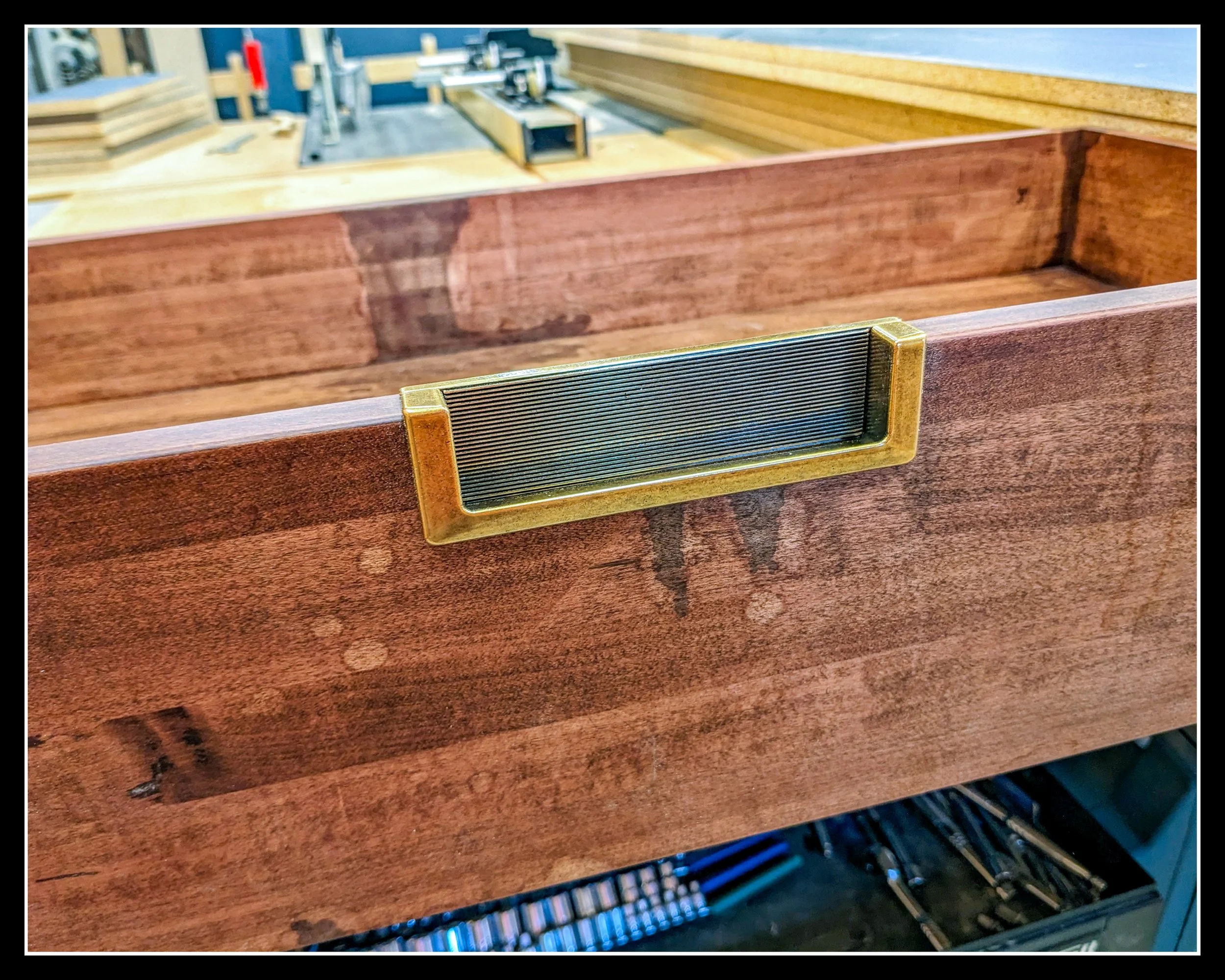 Distressed wooden drawer box with aged marks beneath a fresh finish, showing wear, history, and restored texture.