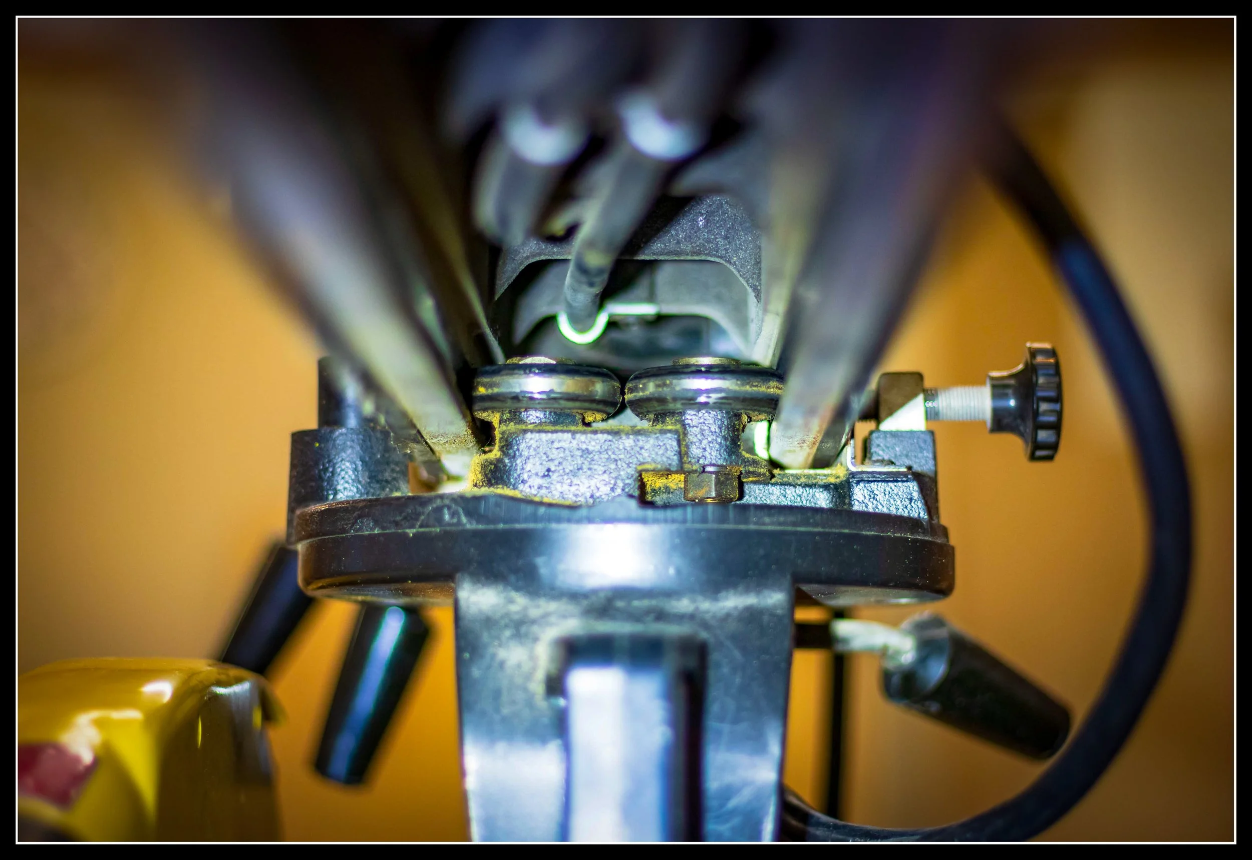 Close‑up of radial arm saw roller bearings inside the cast‑iron arm, showing the clean, dry track used for smooth travel and precise cross‑cutting.