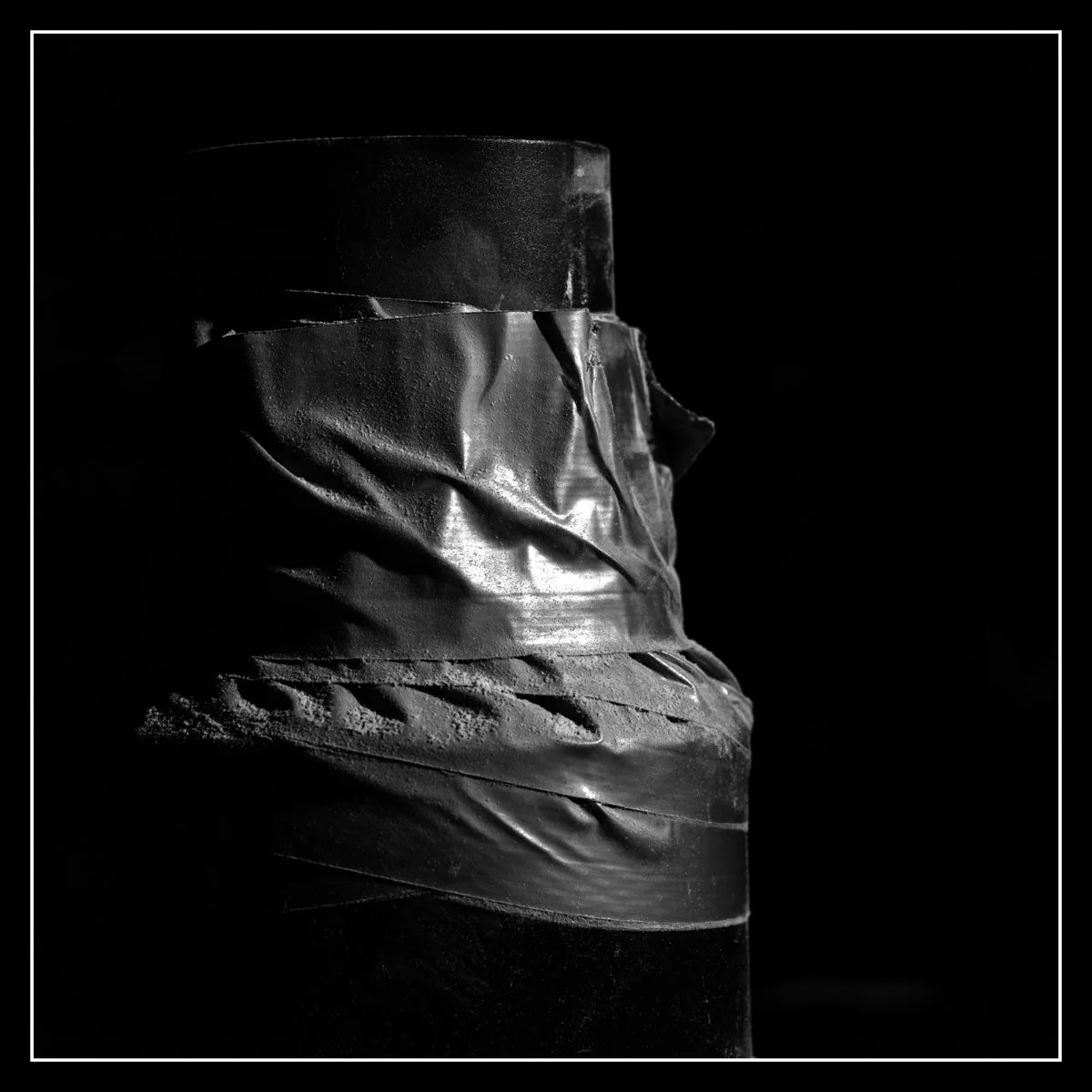 Black and white photo of a dust collection system with duct tape.