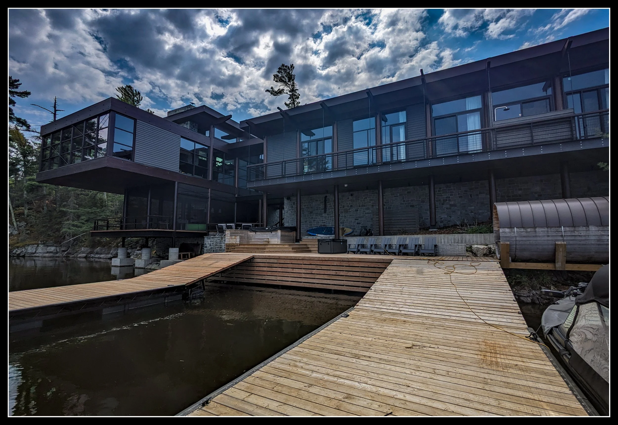 Floating dock built from treated spruce, designed to remain on the lake through winter freeze‑up with multi‑level platforms and modern lakeside construction.