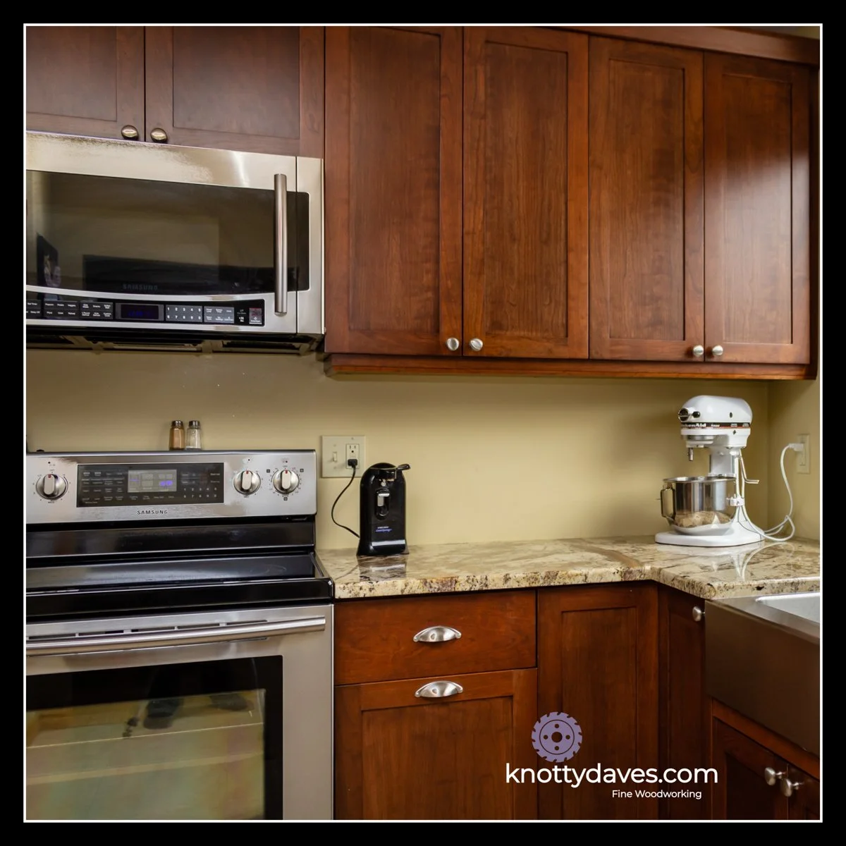 Cherry kitchen cabinetry with warm stained finish, stone countertop, and clean modern layout.