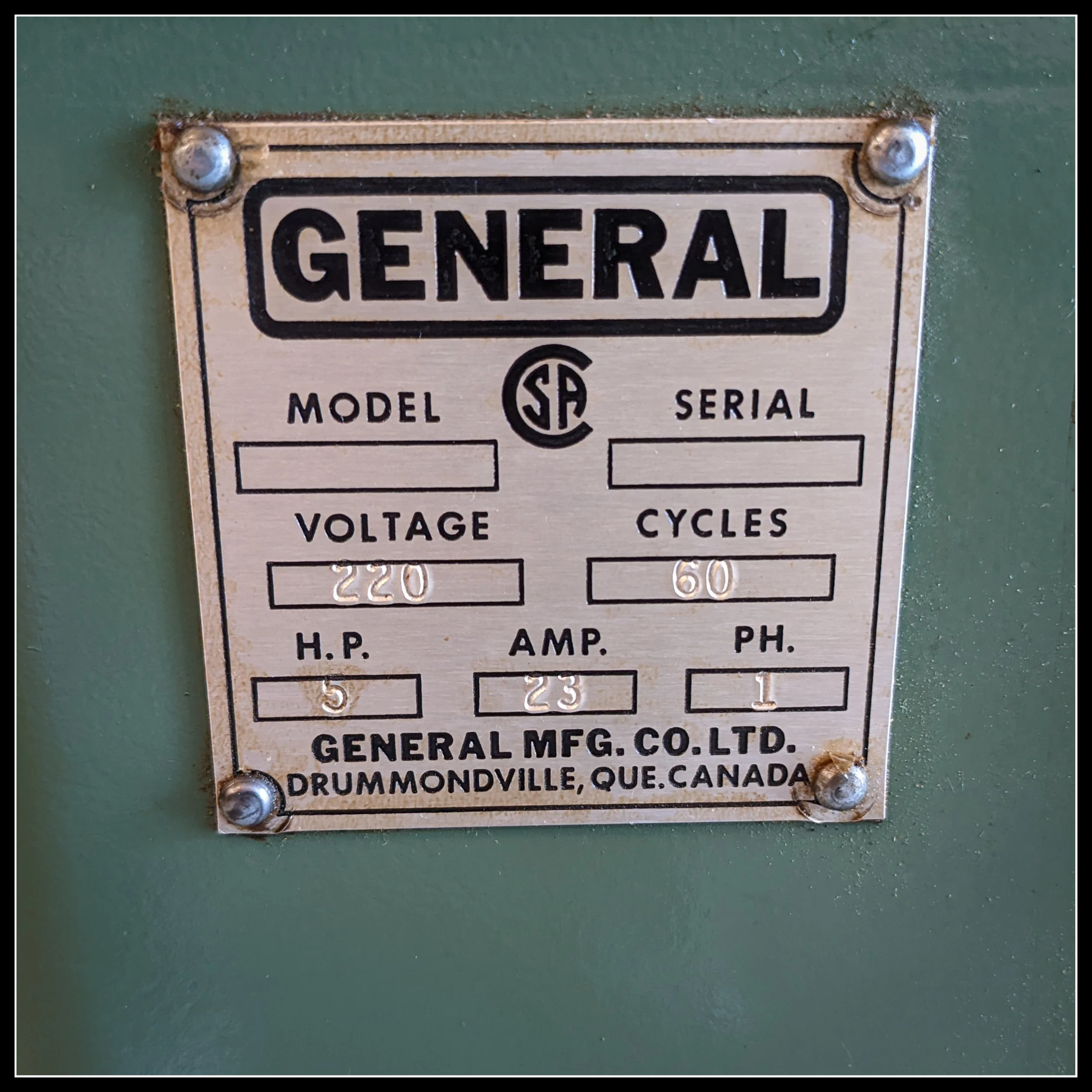 Metal ID tag on a General 130 thickness planer showing 220 V, 5 HP, 23 A single‑phase specifications.