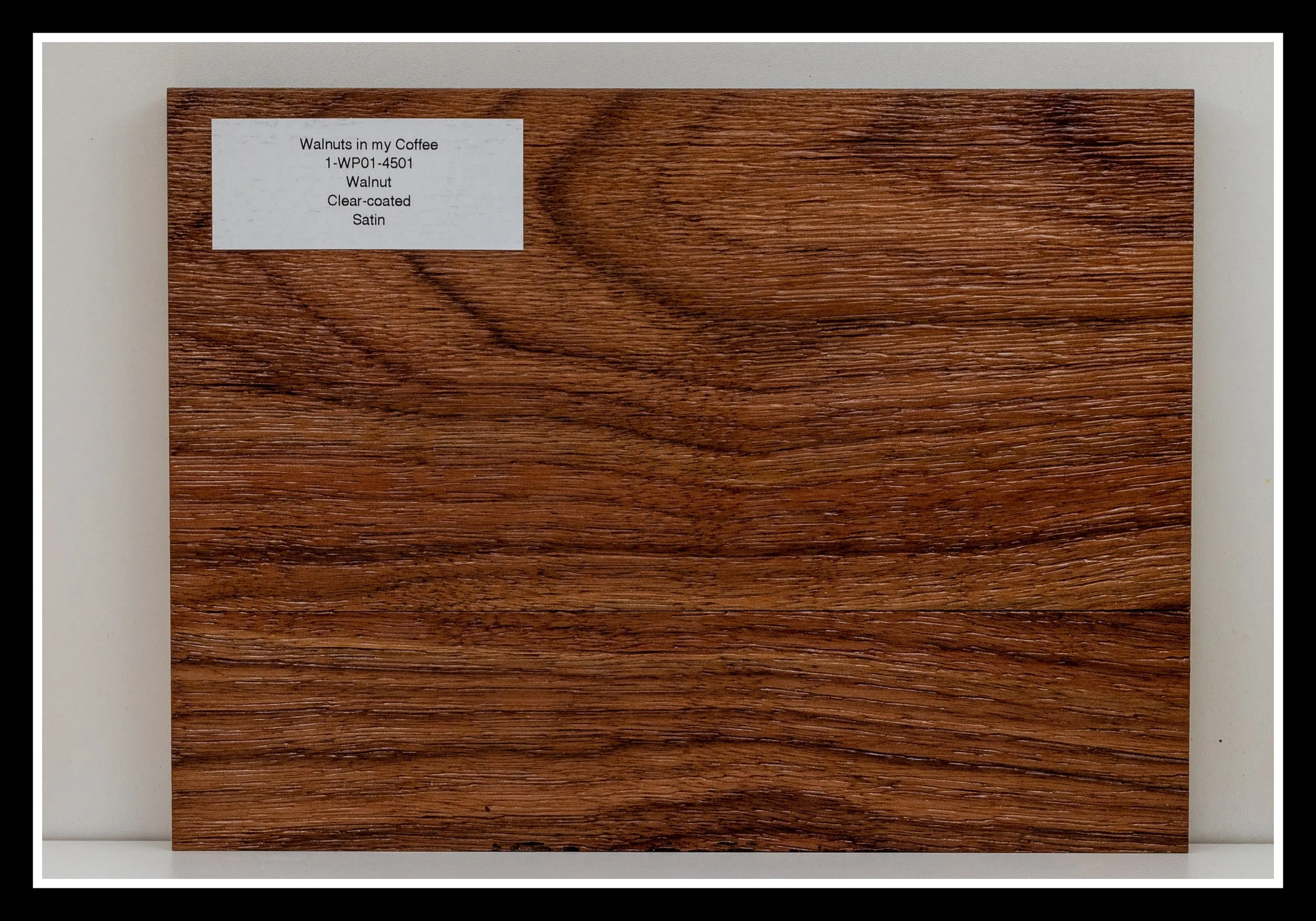 Close‑up of walnut wood grain with deep scraping, warm stain, brushed texture, and a satin 2K poly finish.