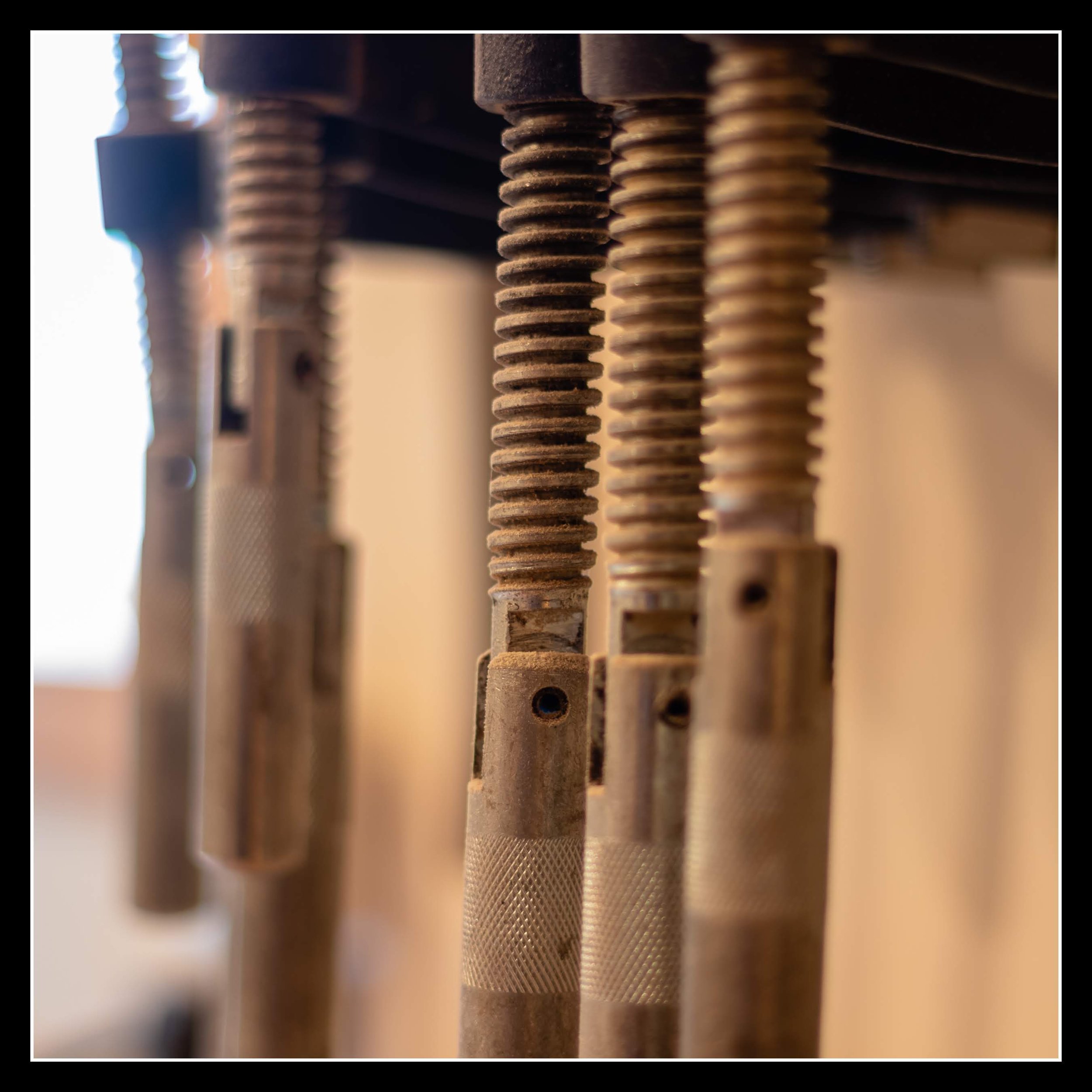 Old Canadian Tire clamps with flat bars and loose jaws, showing worn metal and threaded rods from early woodworking days.